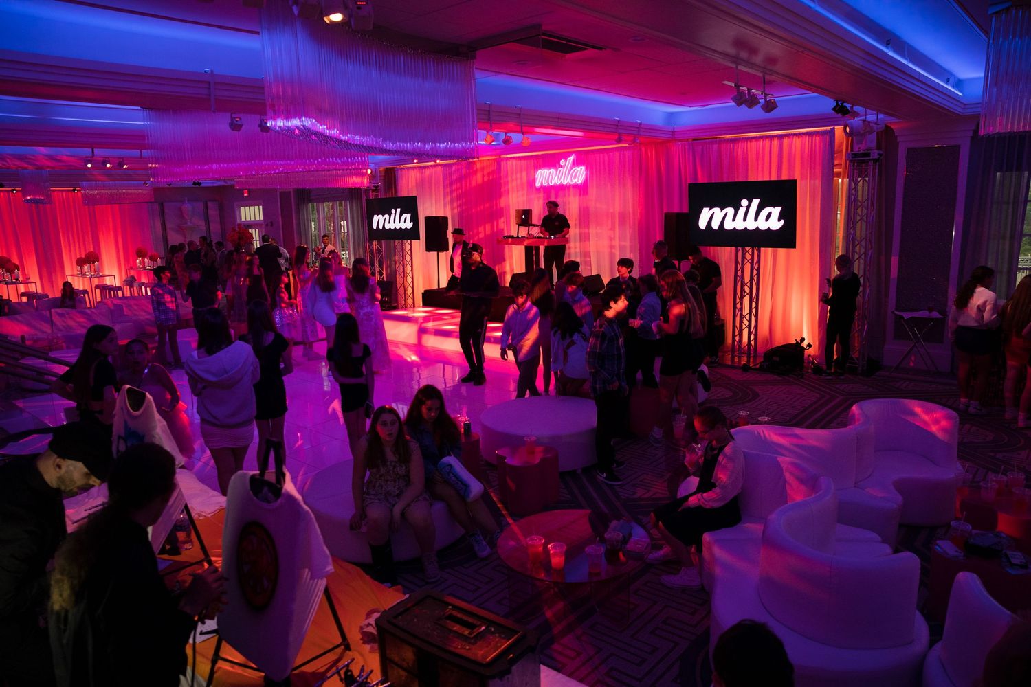 Crowded dance floor at a party with red and blue lighting effects.