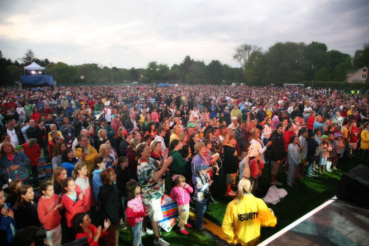 Large outdoor crowd gathered at a daytime festival or concert event.