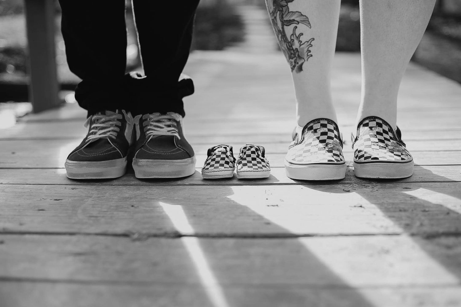 Three pairs of sneakers lined up showing adult and baby sizes in black and white.