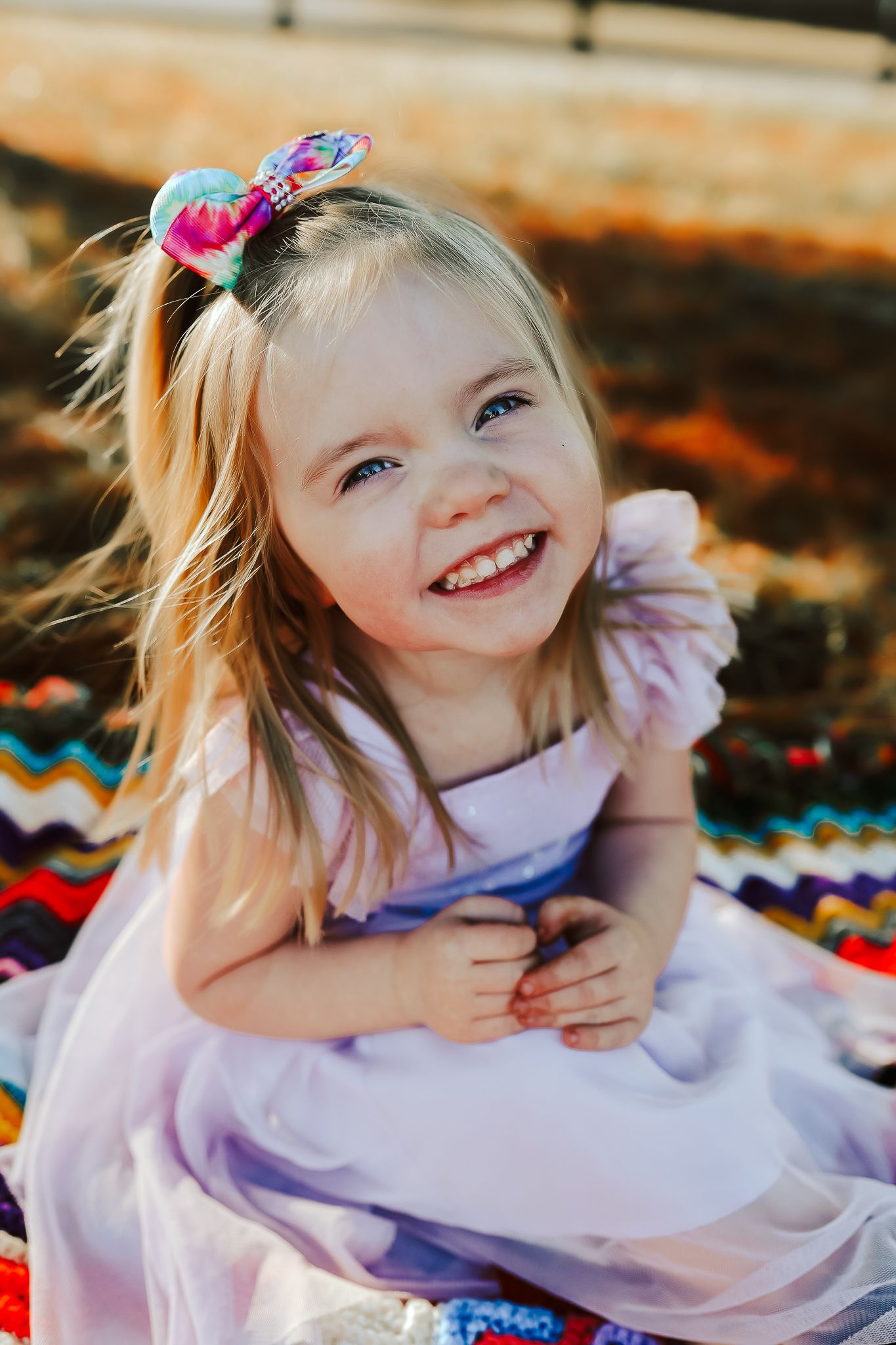 A springtime portrait on a colorful blanket showing joy and laughter.