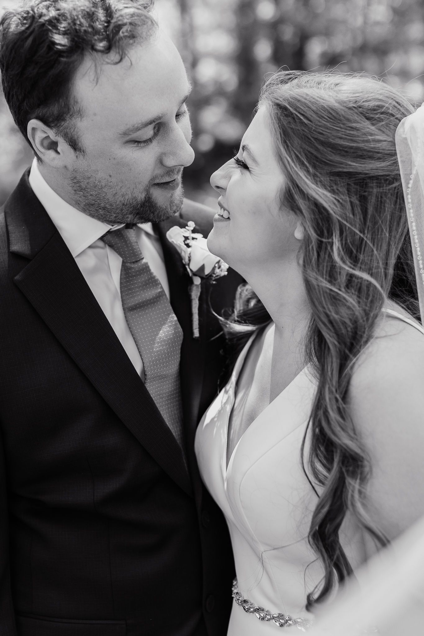 Close-up black and white portrait of newlyweds sharing loving moment together.