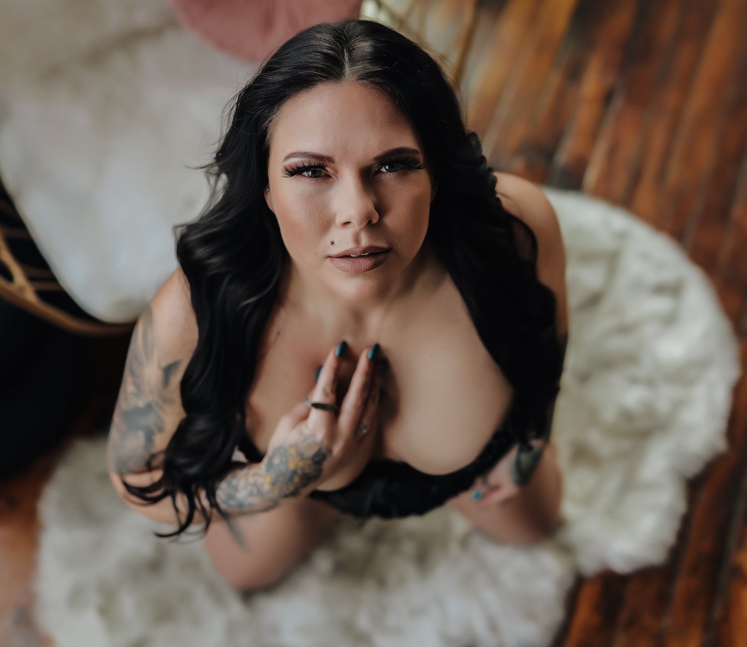 Intimate portrait with dark hair against wooden backdrop in moody lighting.