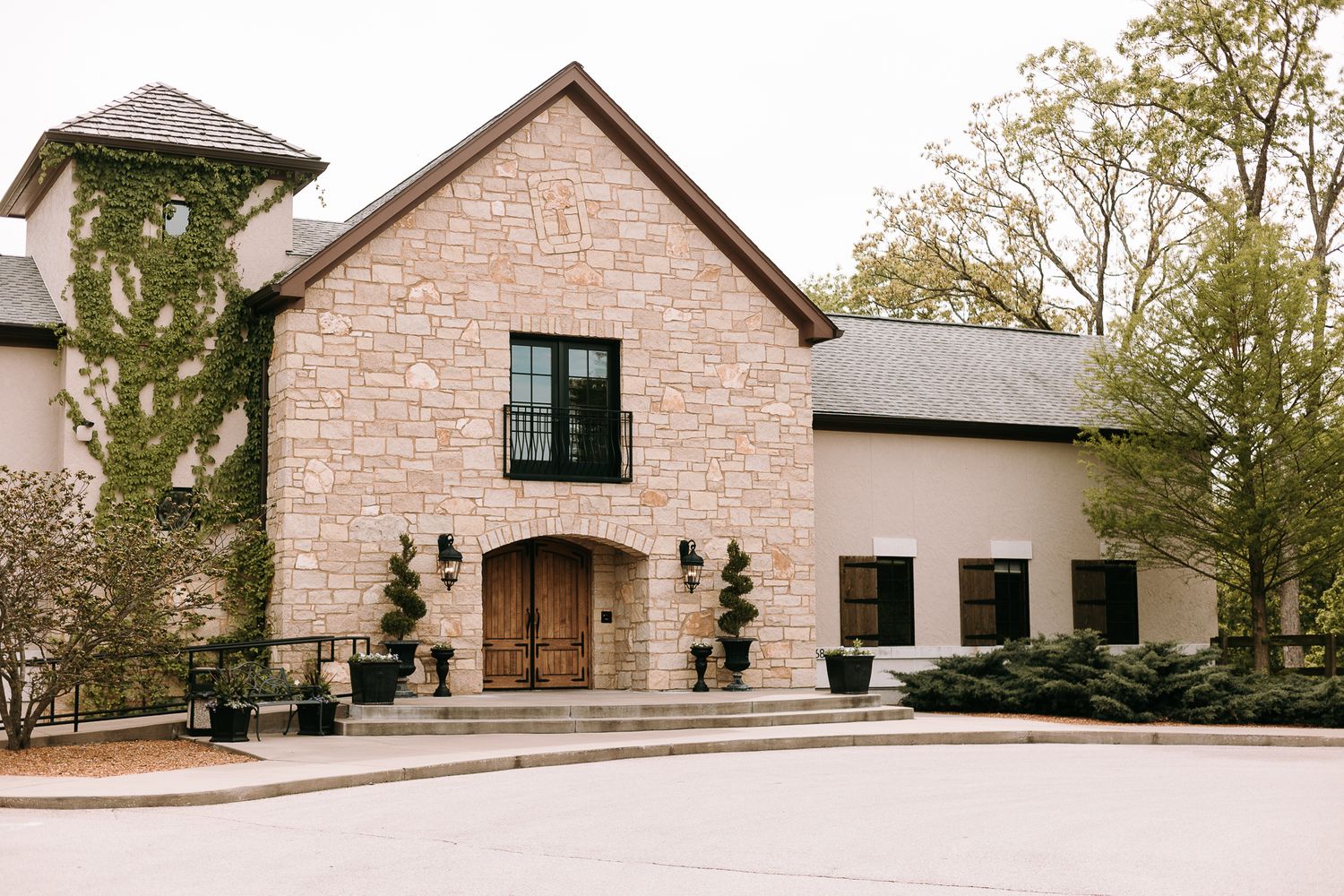 Elegant stone wedding venue with wooden doors and classic architecture.