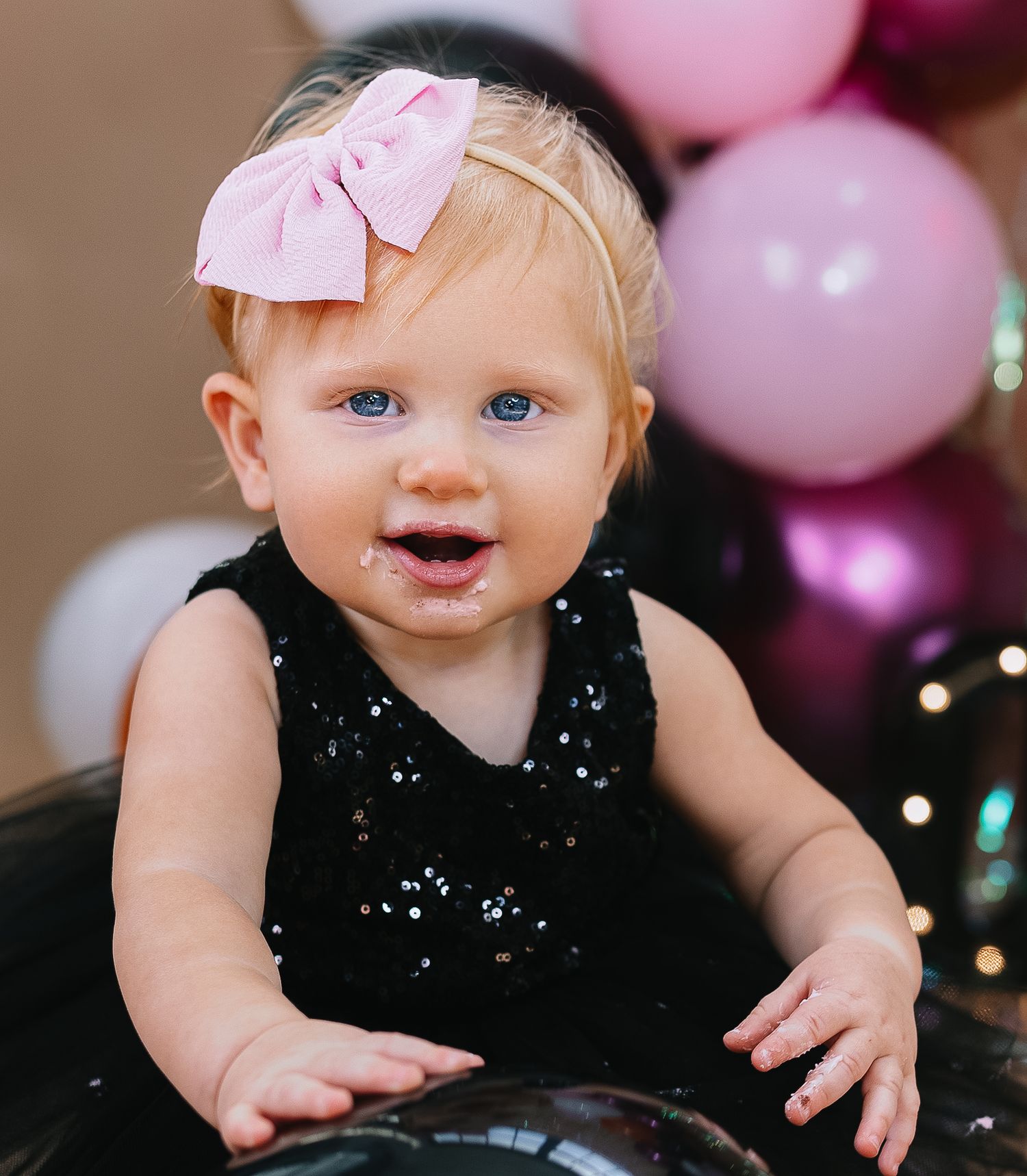 Festive party scene with pink and purple balloons in the background.