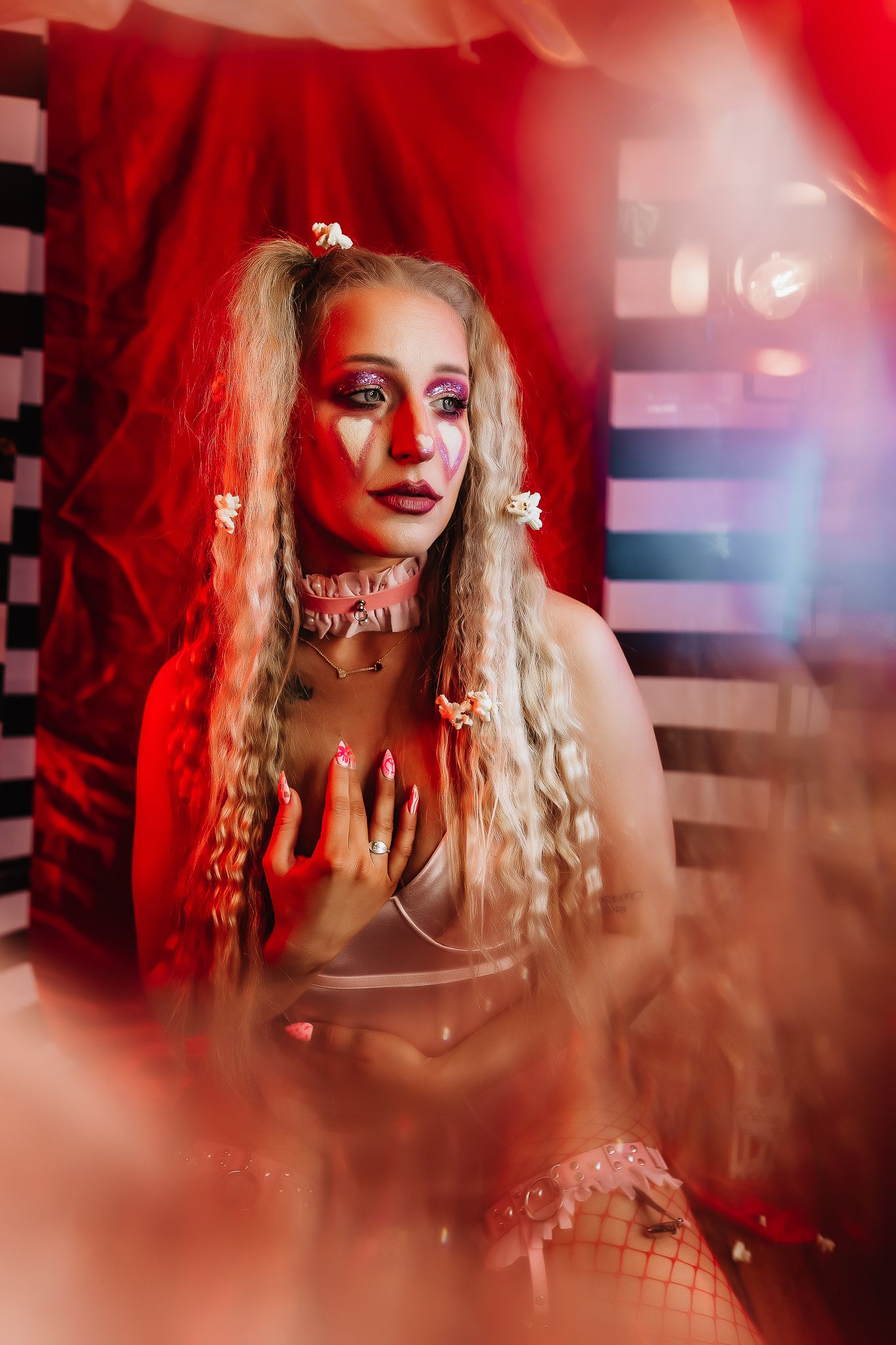 Dramatic portrait with red lighting and gothic styling against checkered backdrop.