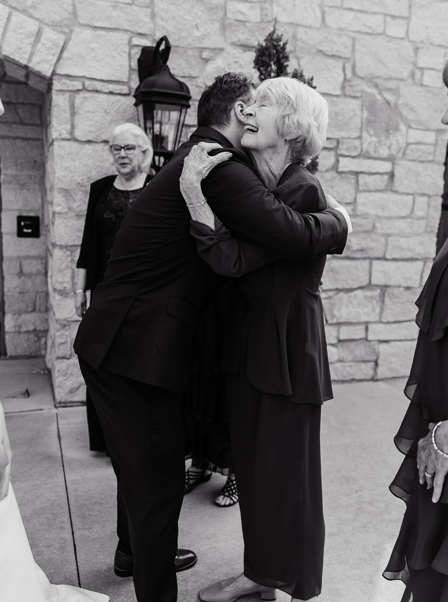 Black and white photo showing emotional embrace at formal event.