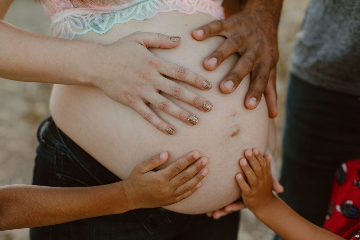 Outdoor maternity photo shoot near Phoenix with cactus and mountain views