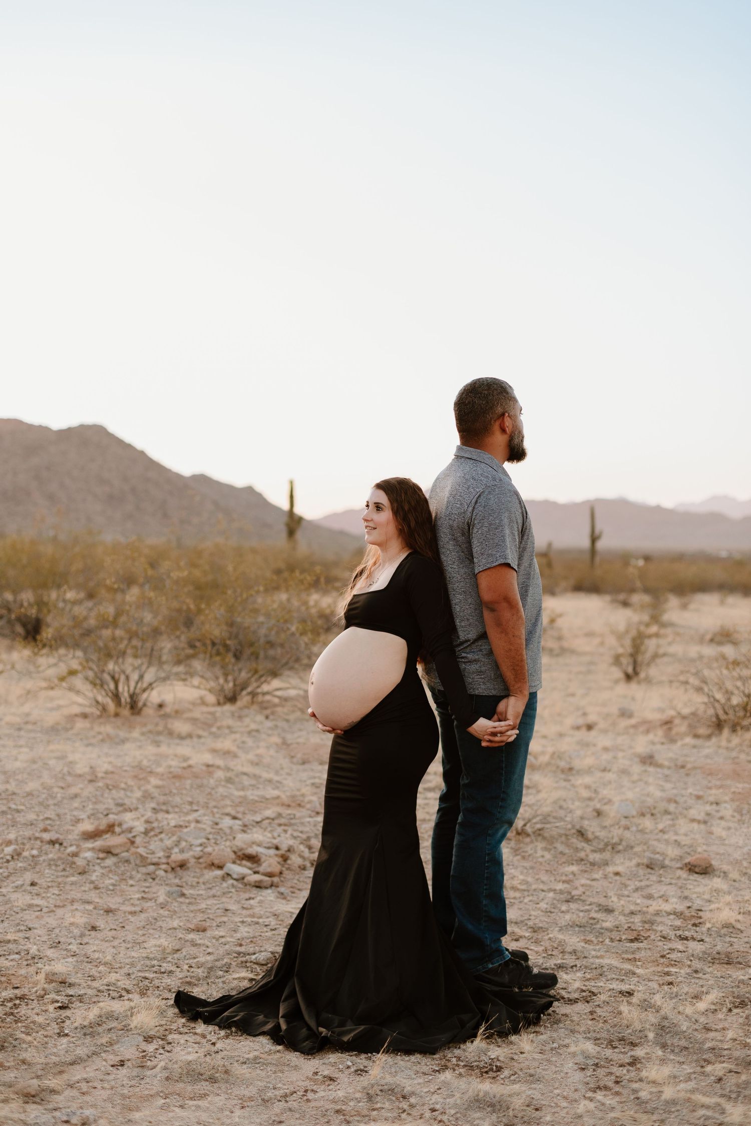 Outdoor maternity photo shoot near Phoenix with cactus and mountain views