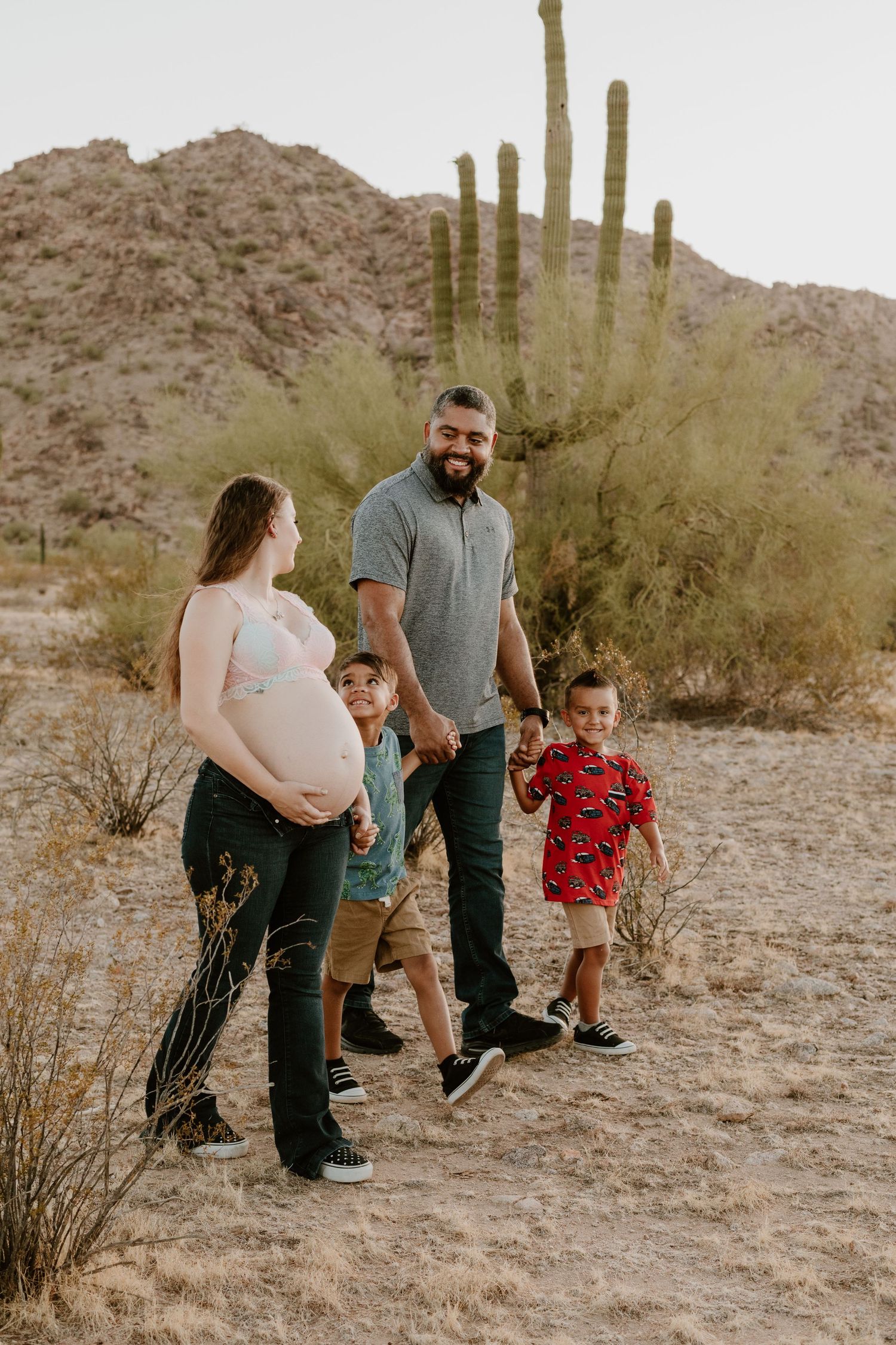 Outdoor maternity photo shoot near Phoenix with cactus and mountain views