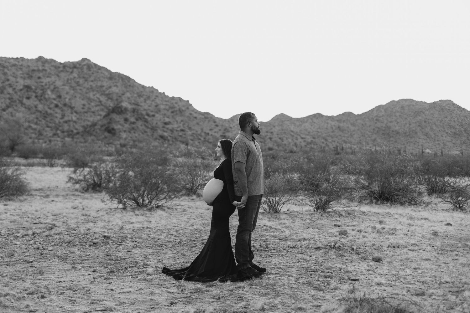 Outdoor maternity photo shoot near Phoenix with cactus and mountain views