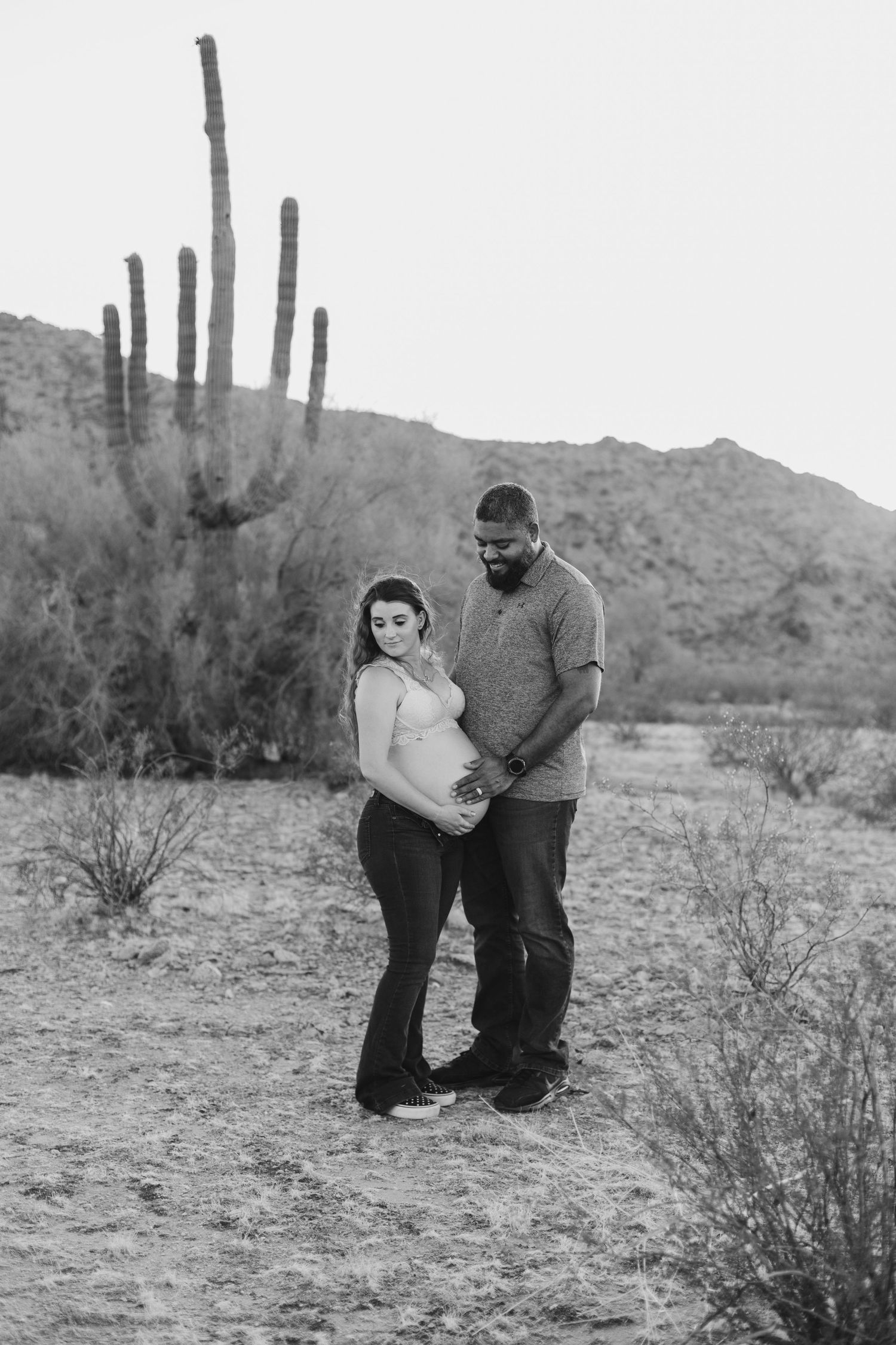 Outdoor maternity photo shoot near Phoenix with cactus and mountain views