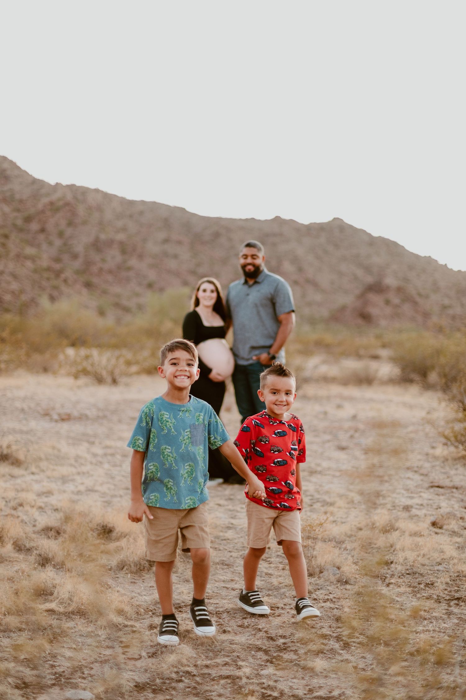 Outdoor maternity photo shoot near Phoenix with cactus and mountain views