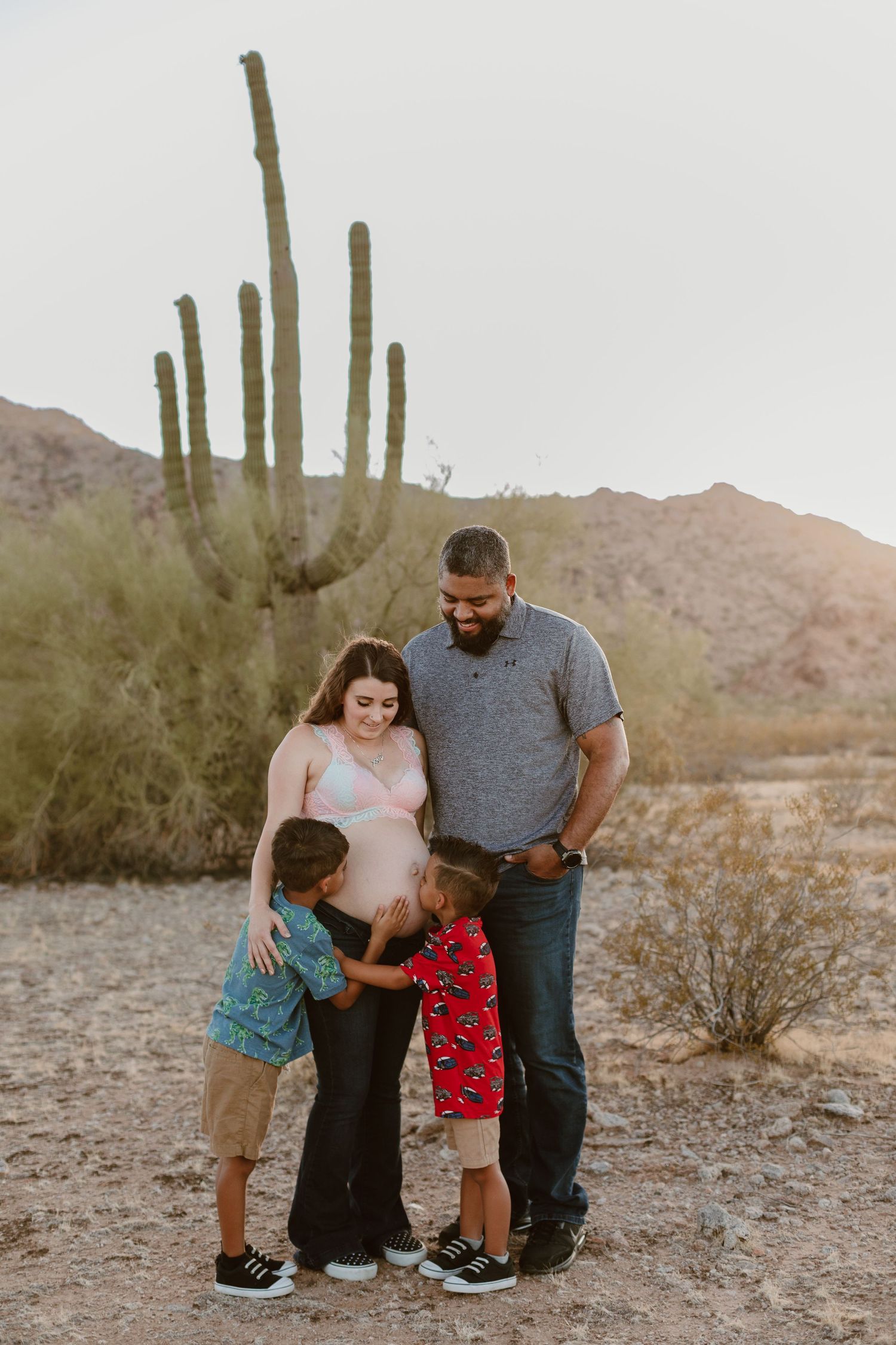 Outdoor maternity photo shoot near Phoenix with cactus and mountain views