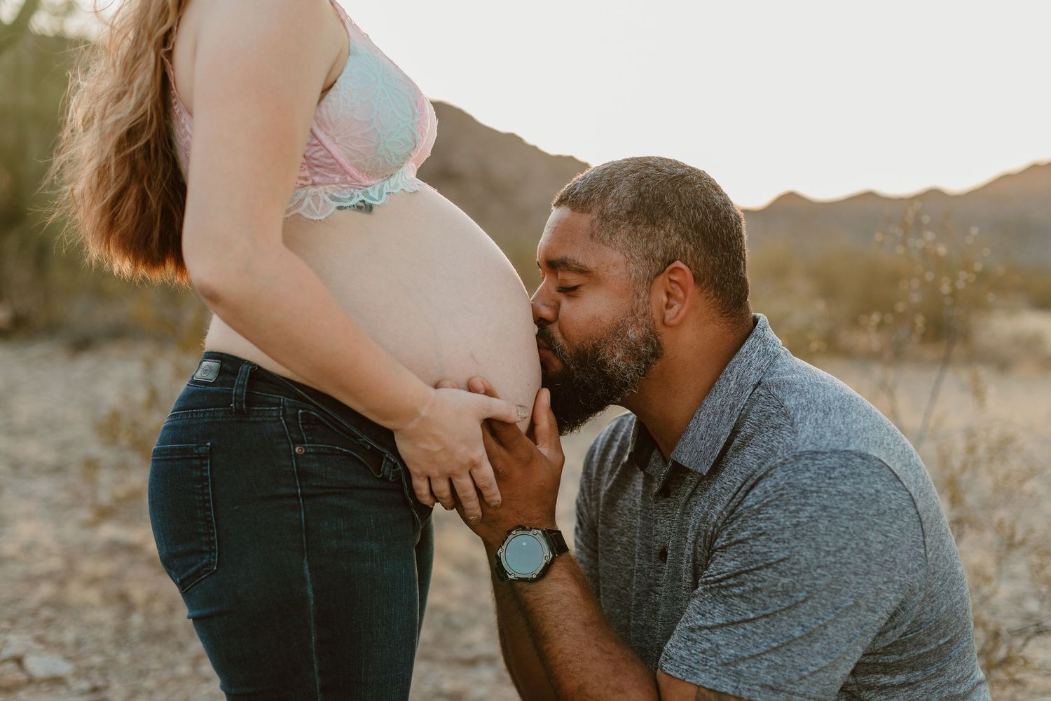 Outdoor maternity photo shoot near Phoenix with cactus and mountain views