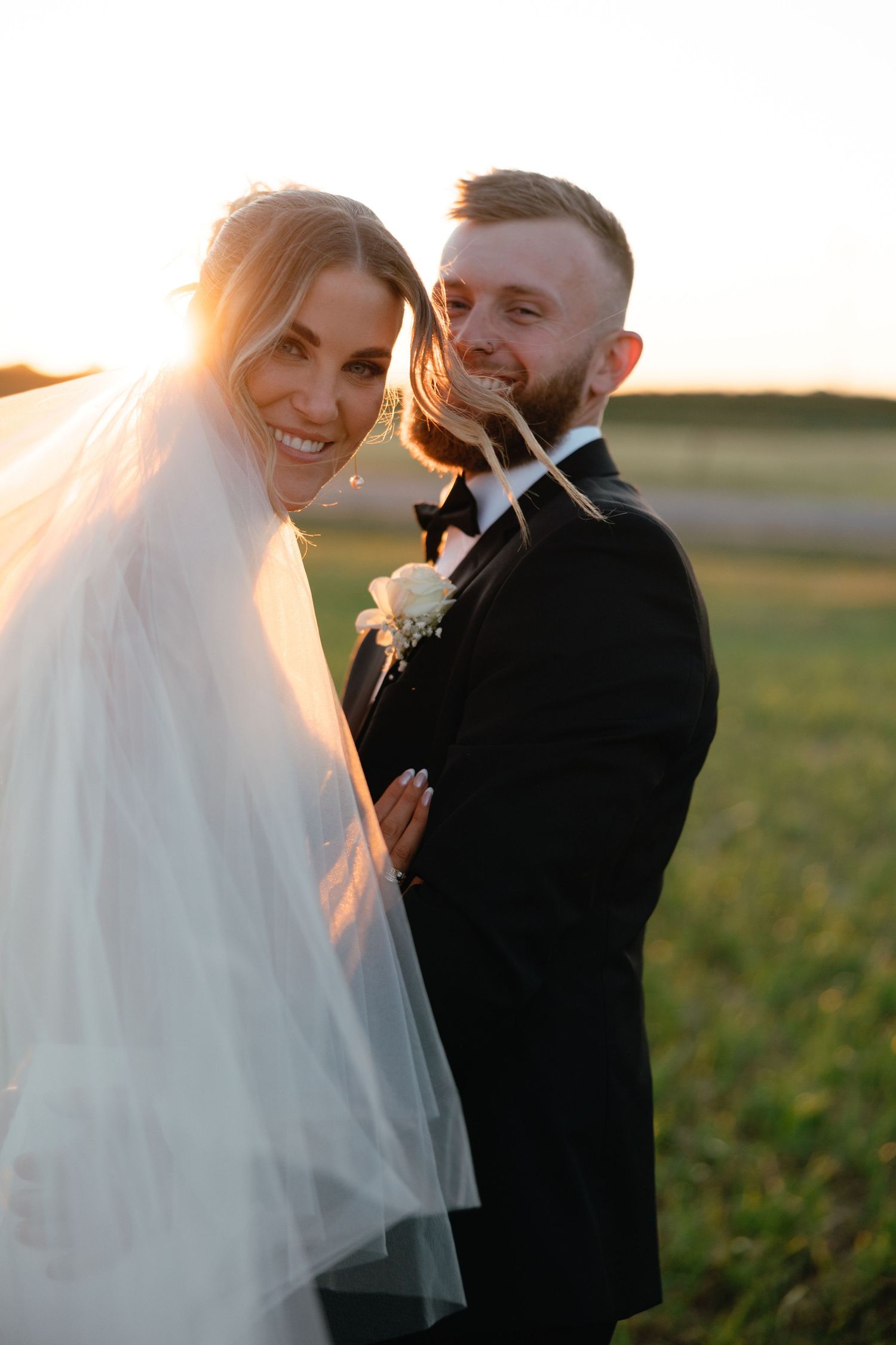 Sunset wedding portrait with couple sharing intimate moment in golden light.