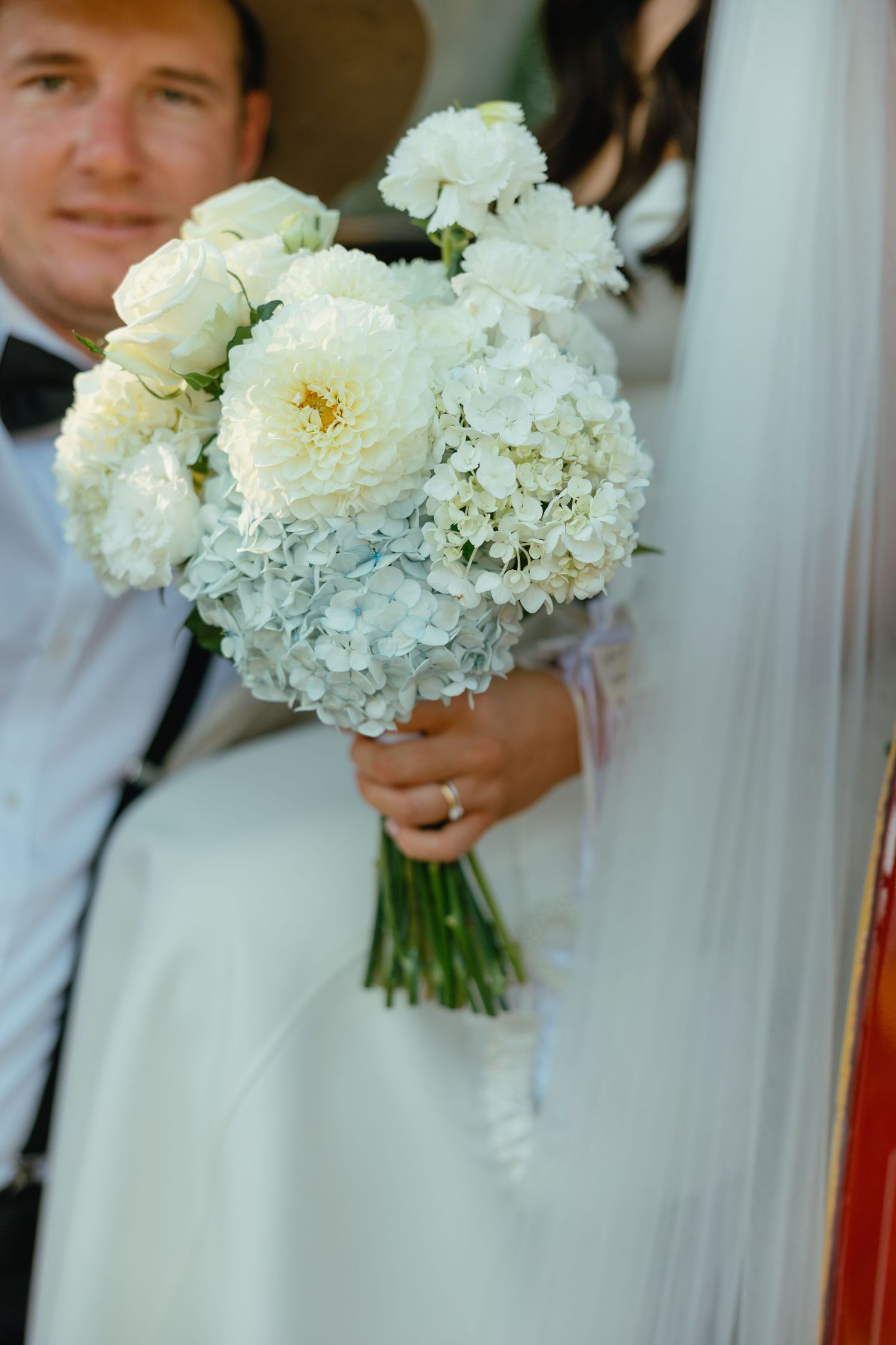 Elegant white and cream bridal bouquet with roses and hydrangeas shot in closeup.