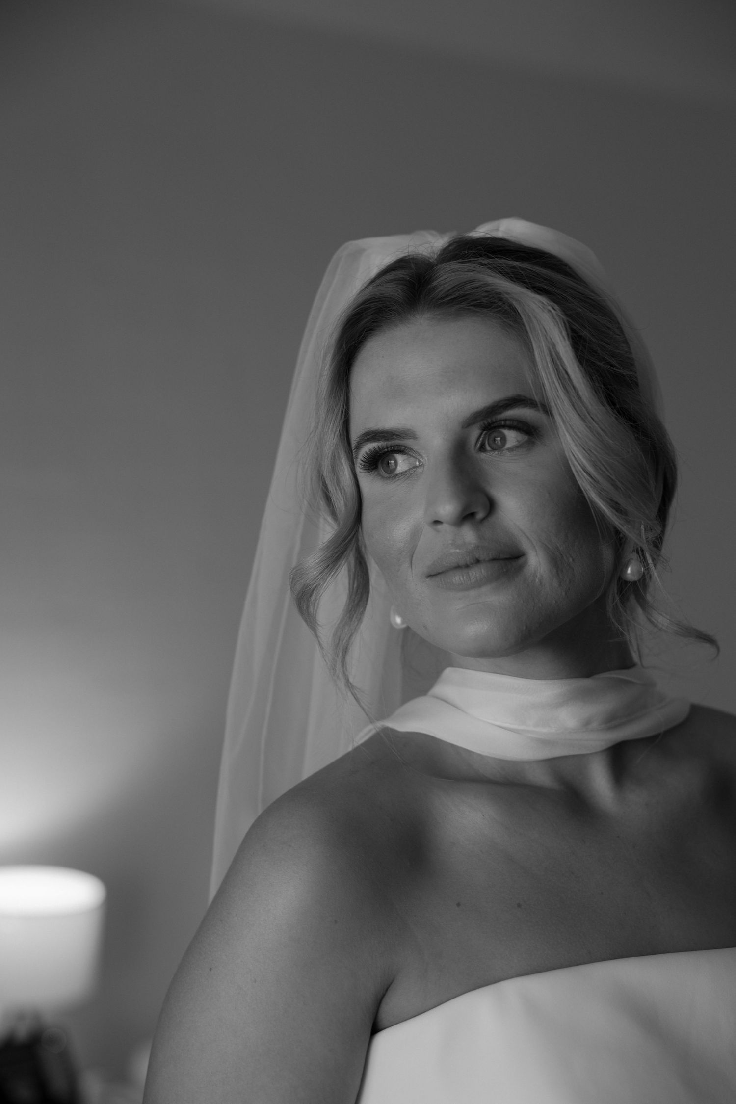 Black and white bridal portrait with soft lighting and candle in background.