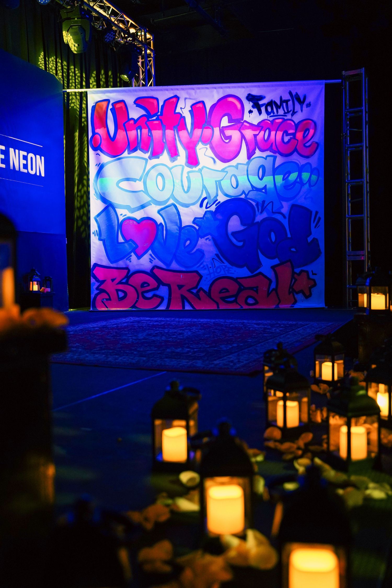 Artistic neon graffiti backdrop with glowing lanterns creating atmospheric lighting.