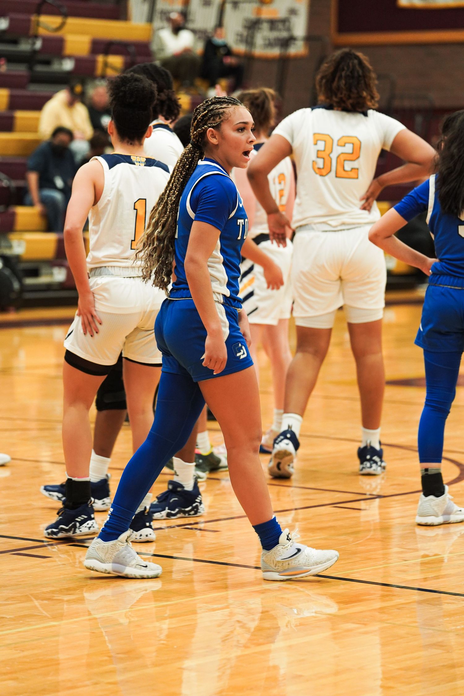 Basketball players in blue and white uniforms competing during an intense game.
