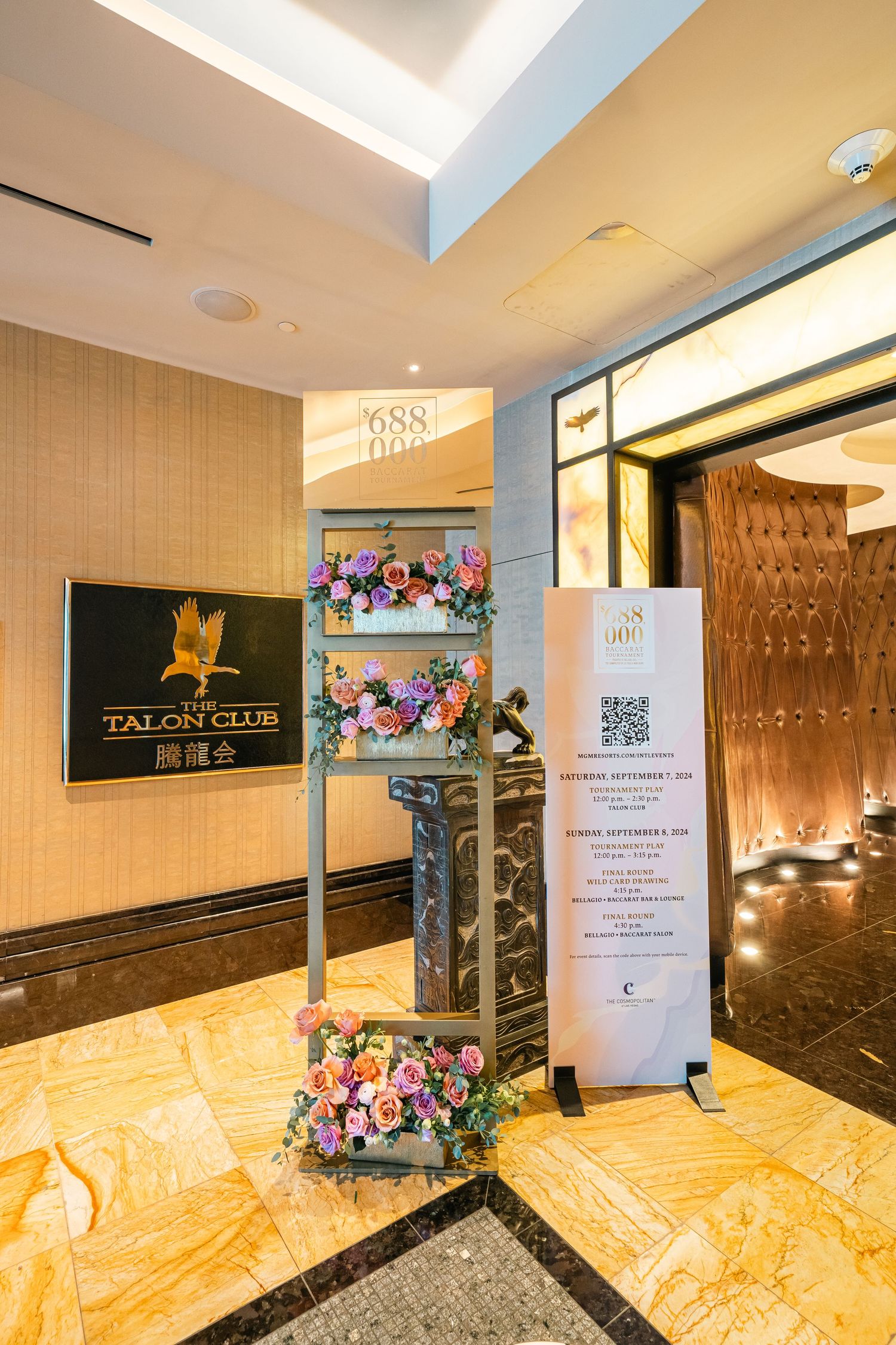 Elegant entrance to Talon Club with floral decorations and modern signage against marble walls.