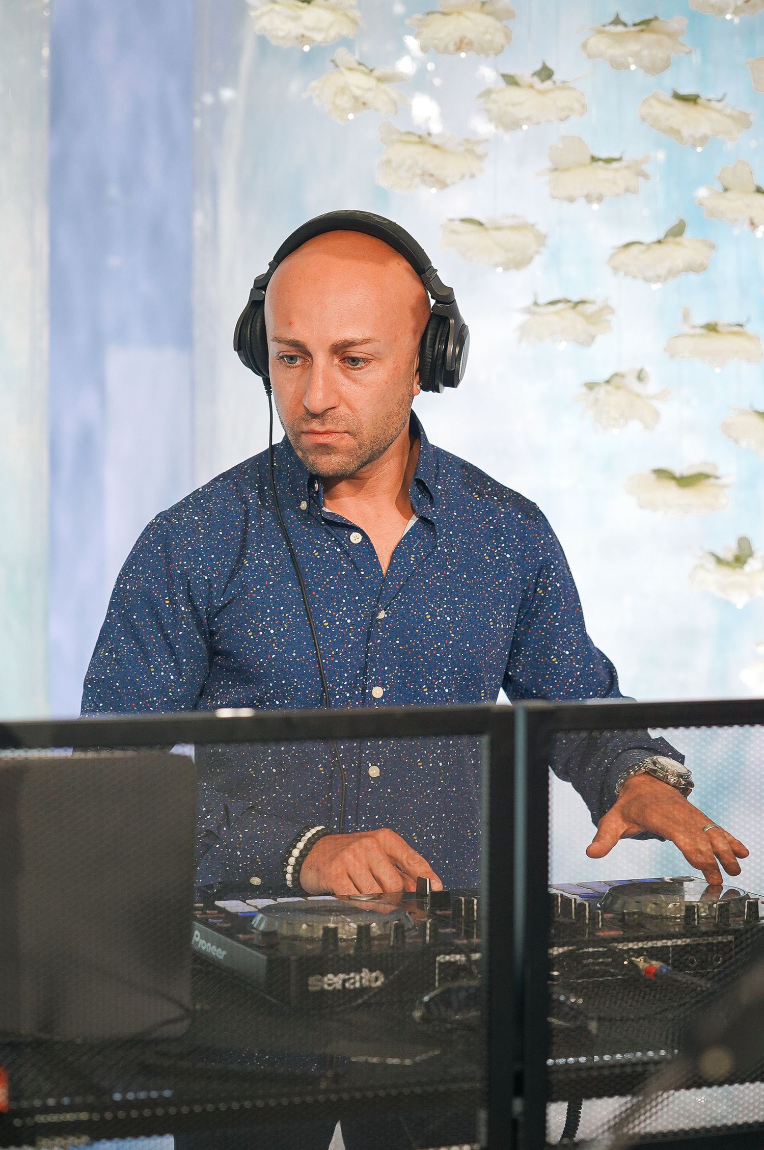 DJ performing at an event with headphones and professional equipment.
