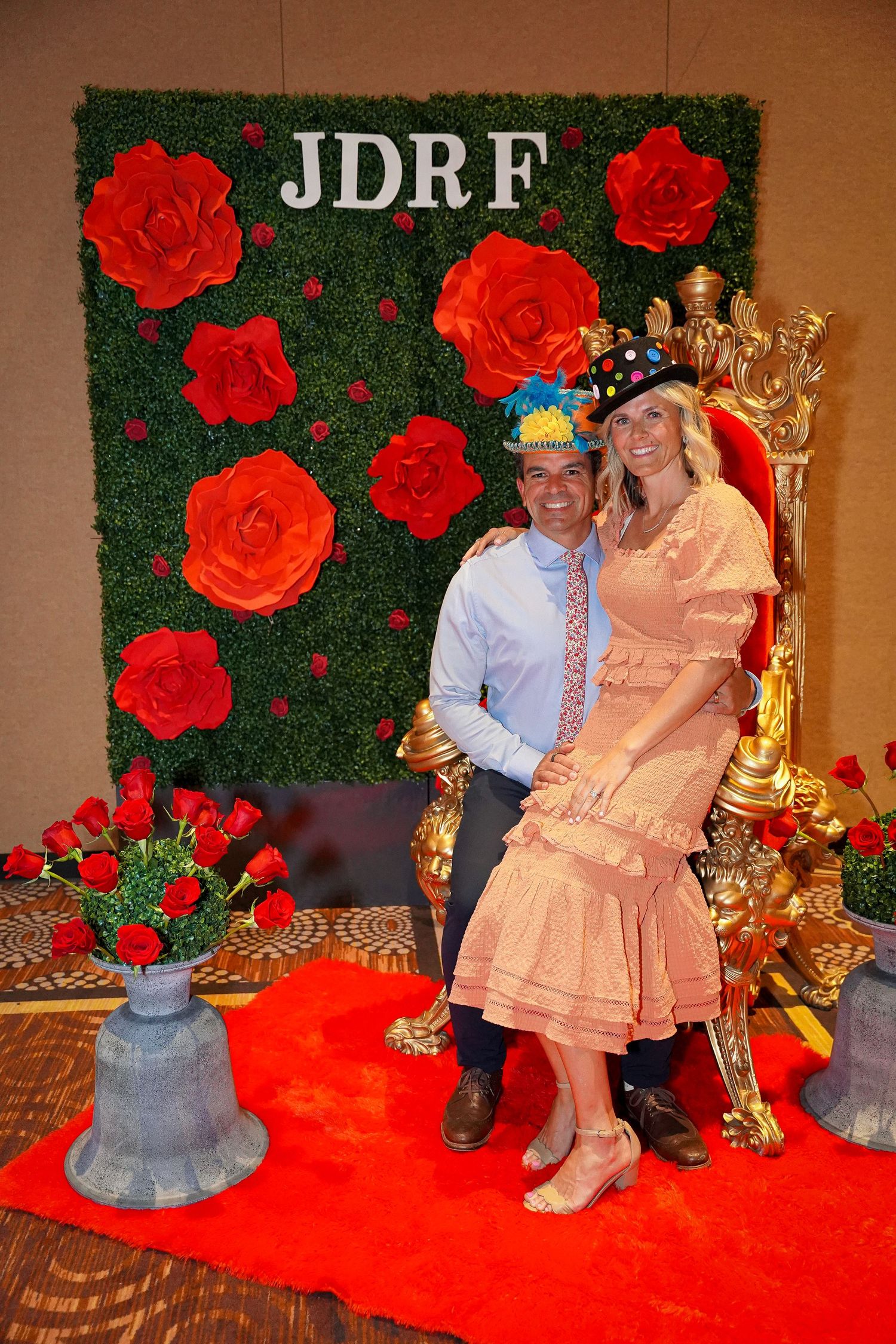 JDRF event photo station with ornate throne and rose-covered backdrop.