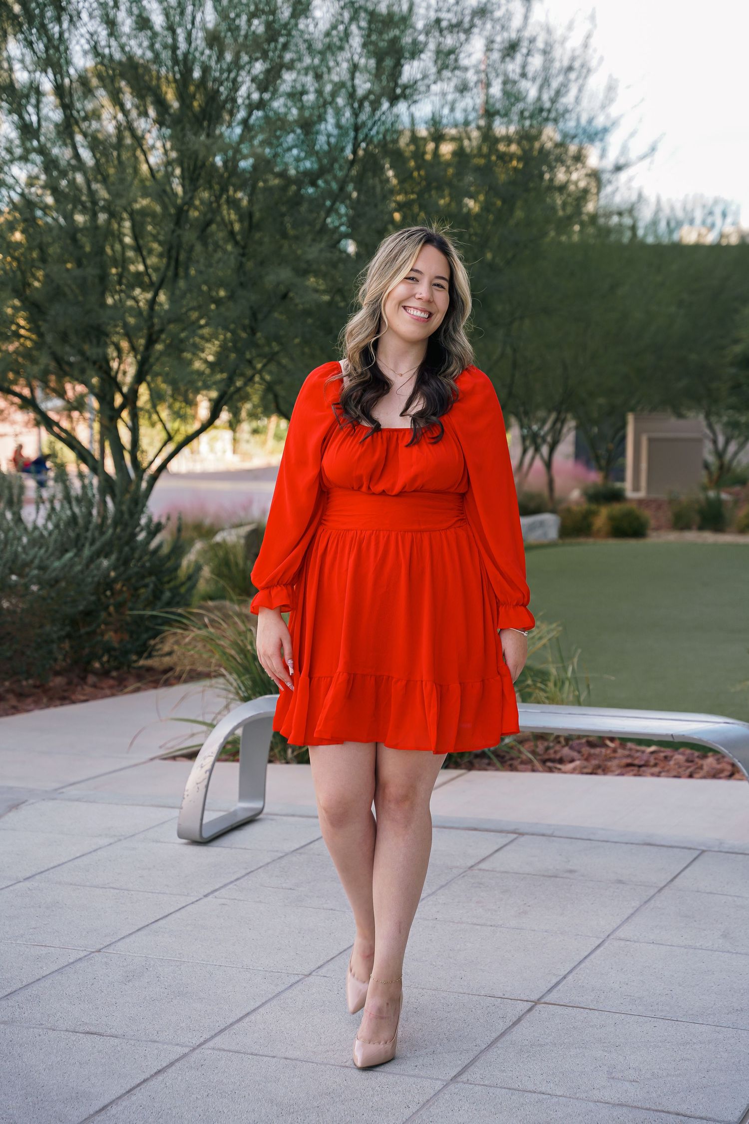 Vibrant red dress photo shoot outdoors on concrete patio during sunset.