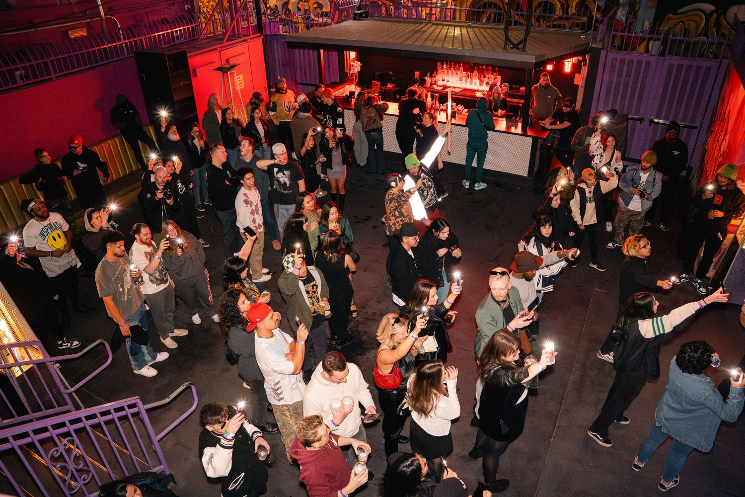 Overhead view of a crowded nightclub dance floor with people gathered in groups.