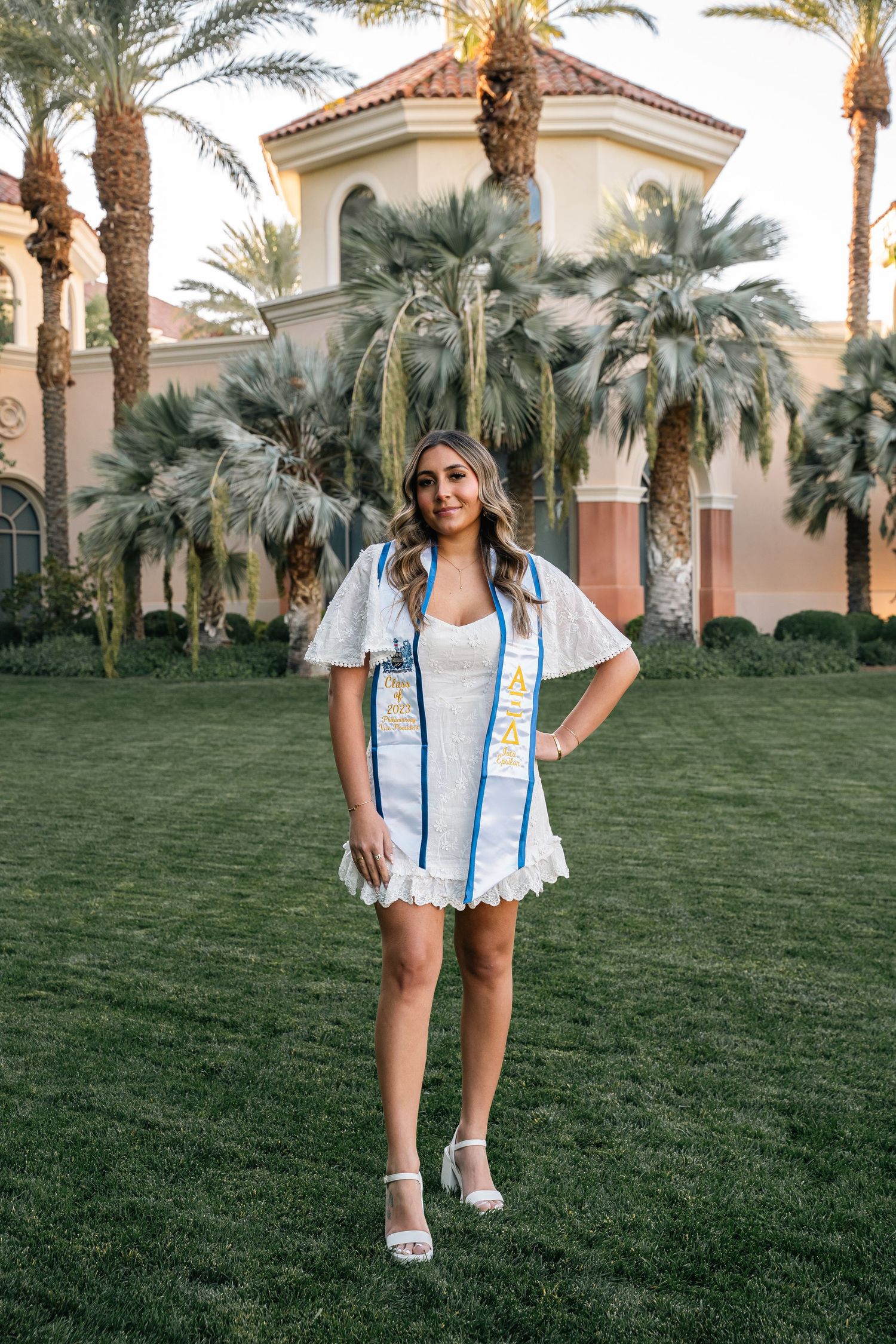 Summer evening photoshoot on resort grounds with palm trees and Spanish architecture.