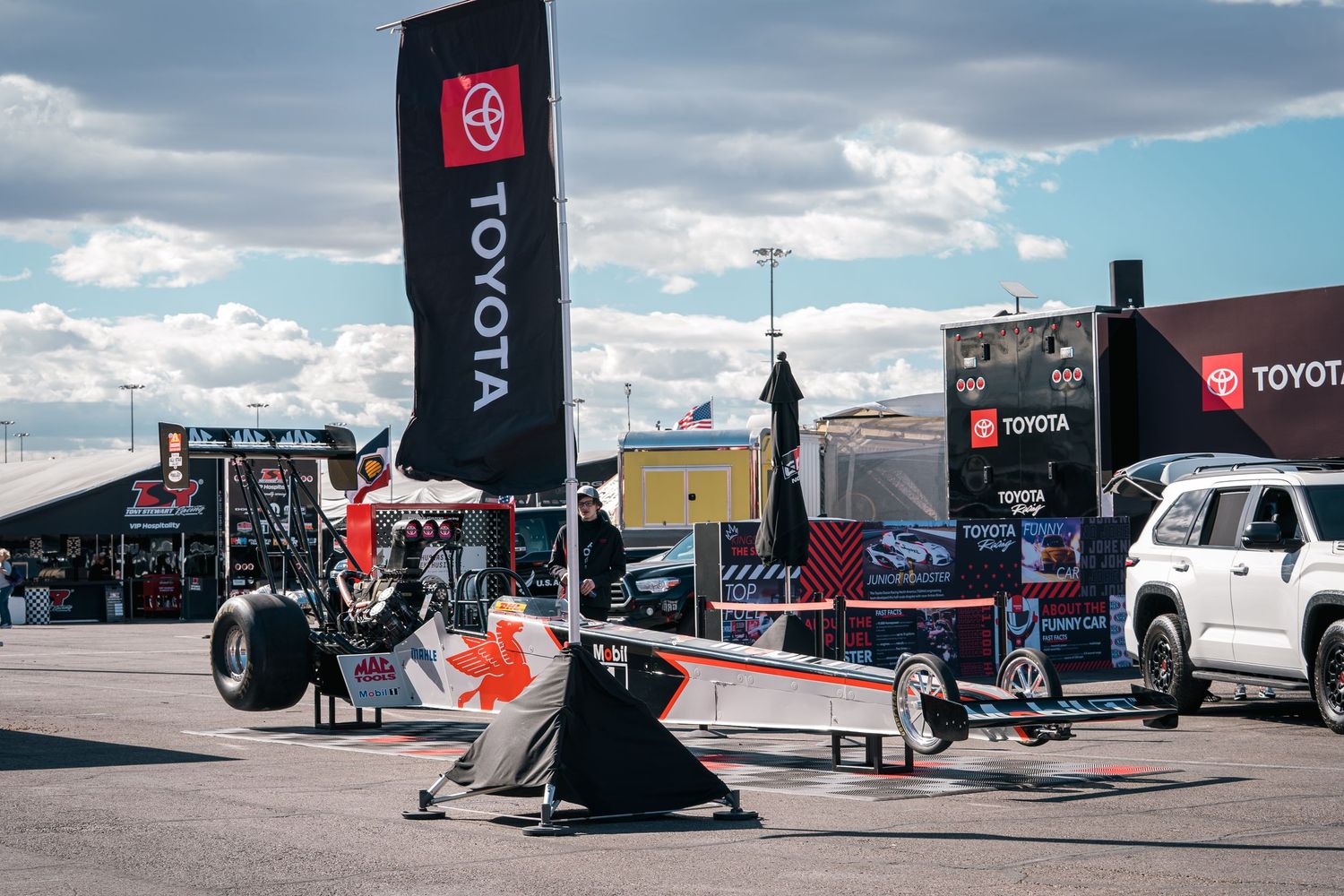 Racing equipment and gear displayed at outdoor motorsports event with Toyota branding.