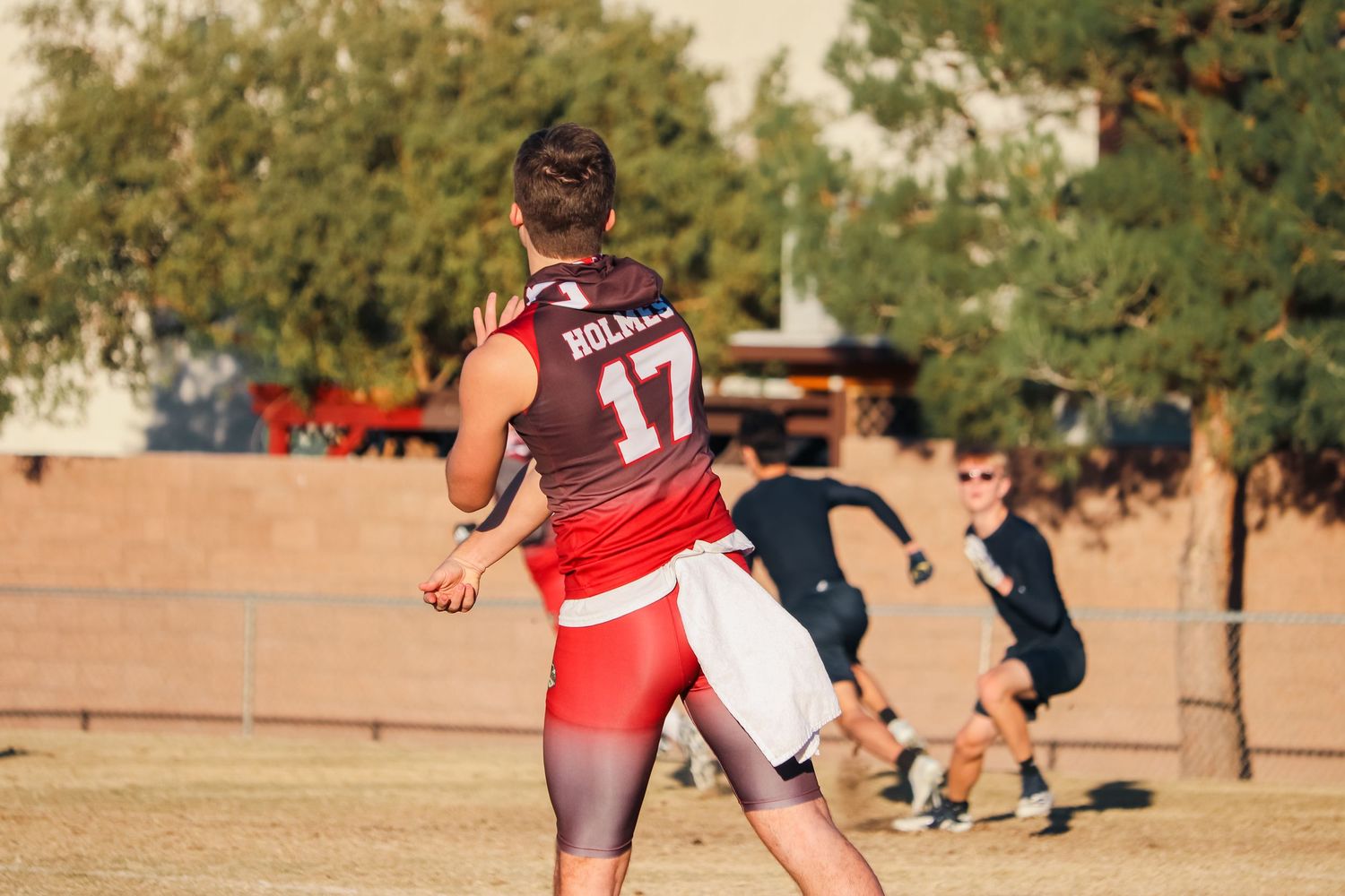 Player in red uniform prepares to make a play during flag football match.
