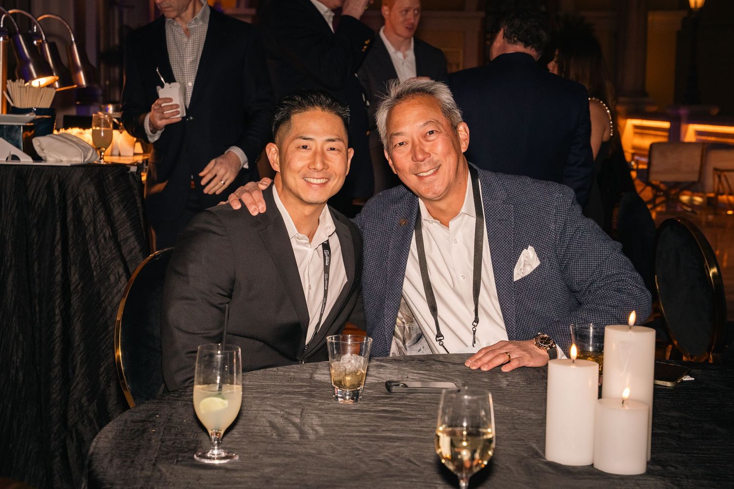 Two business professionals sharing drinks at formal evening event.