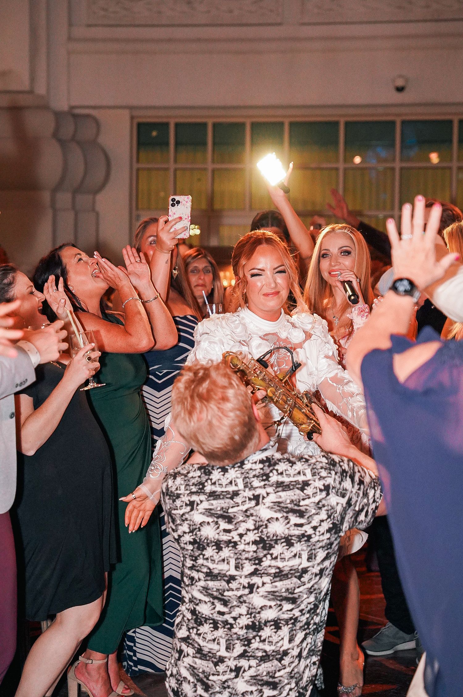 Energetic crowd dancing and celebrating at a wedding reception.
