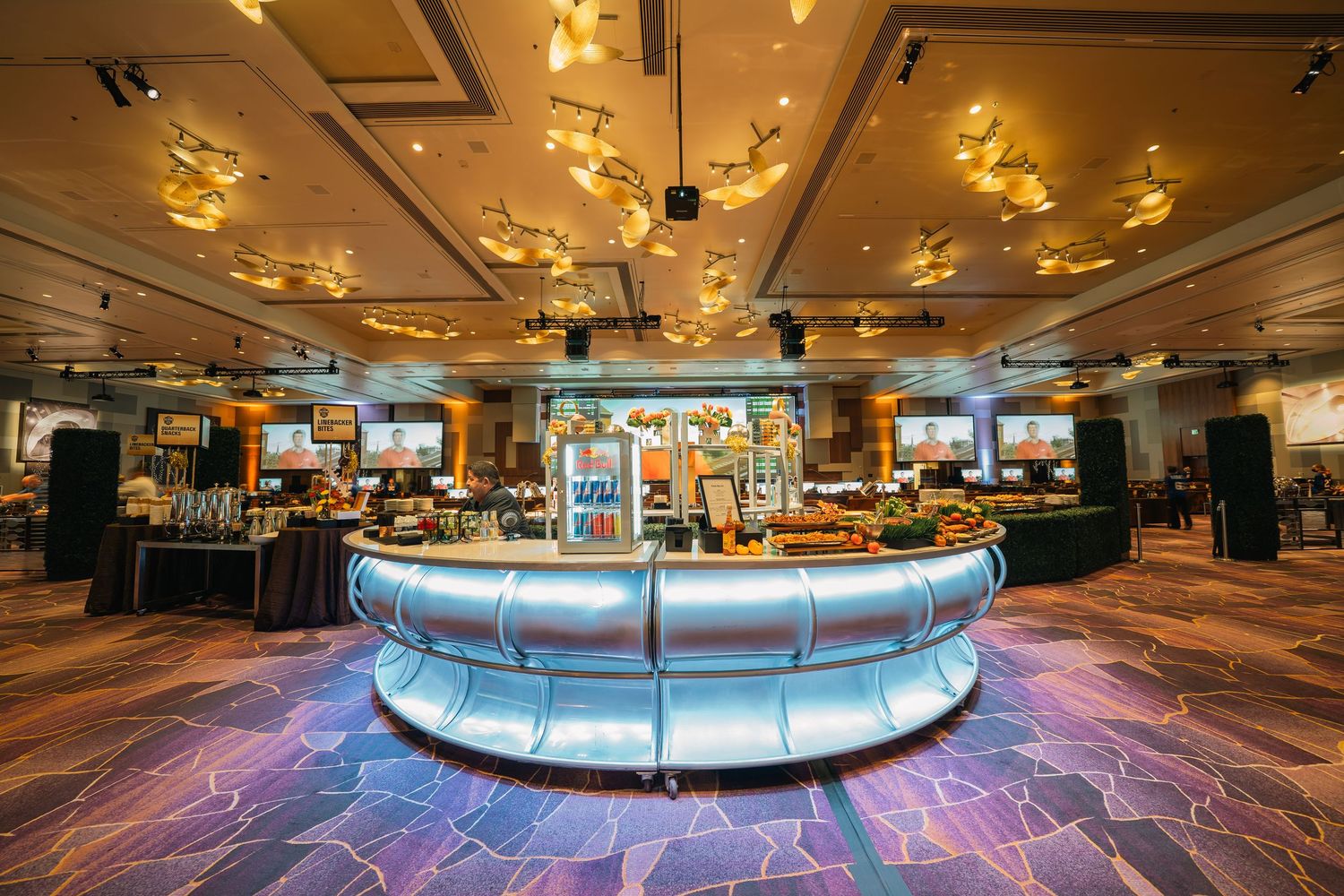 Panoramic view of a modern casino floor featuring illuminated circular bar and gaming areas.