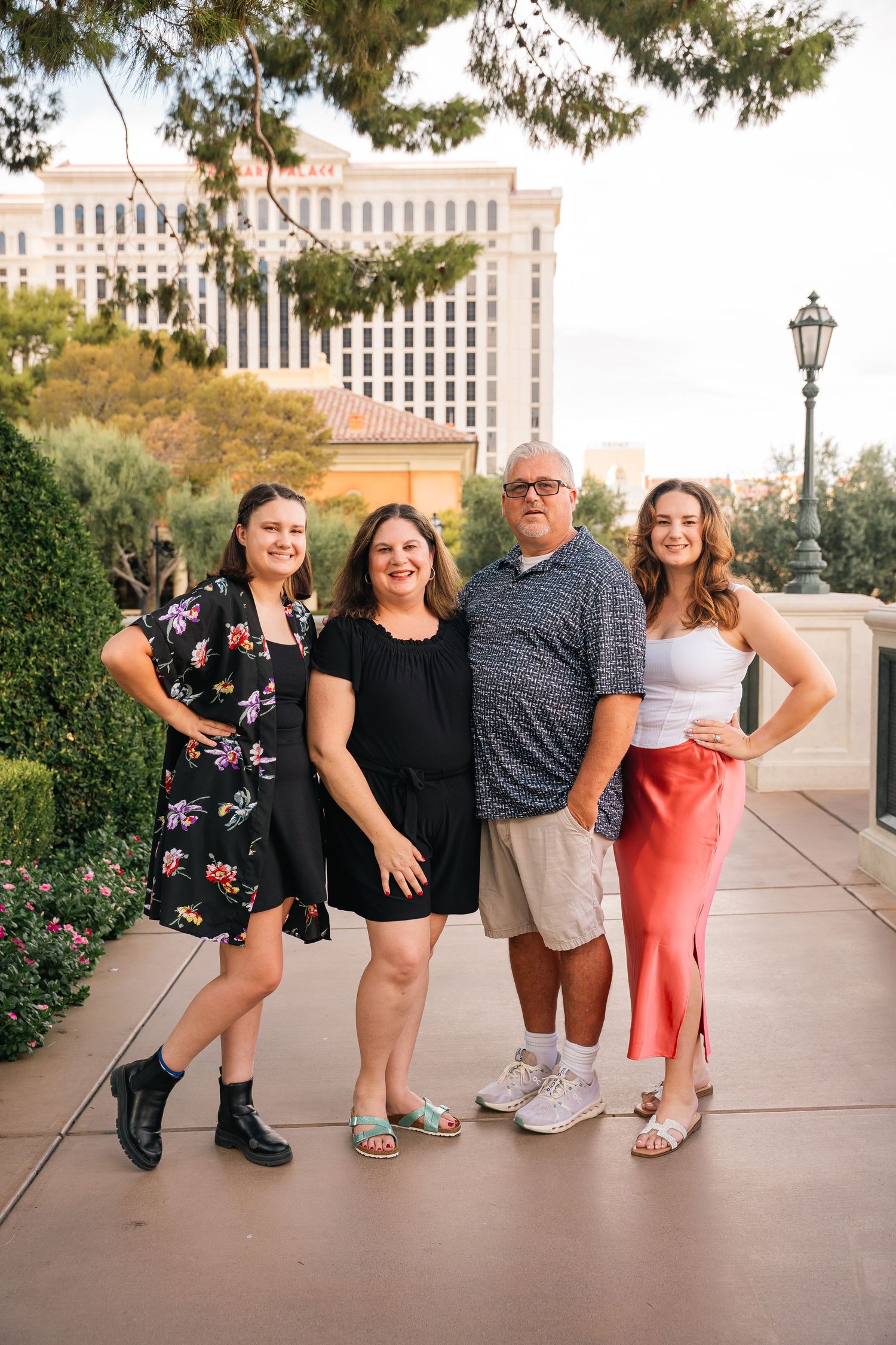 Fun group poses on outdoor walkway with city buildings in background.