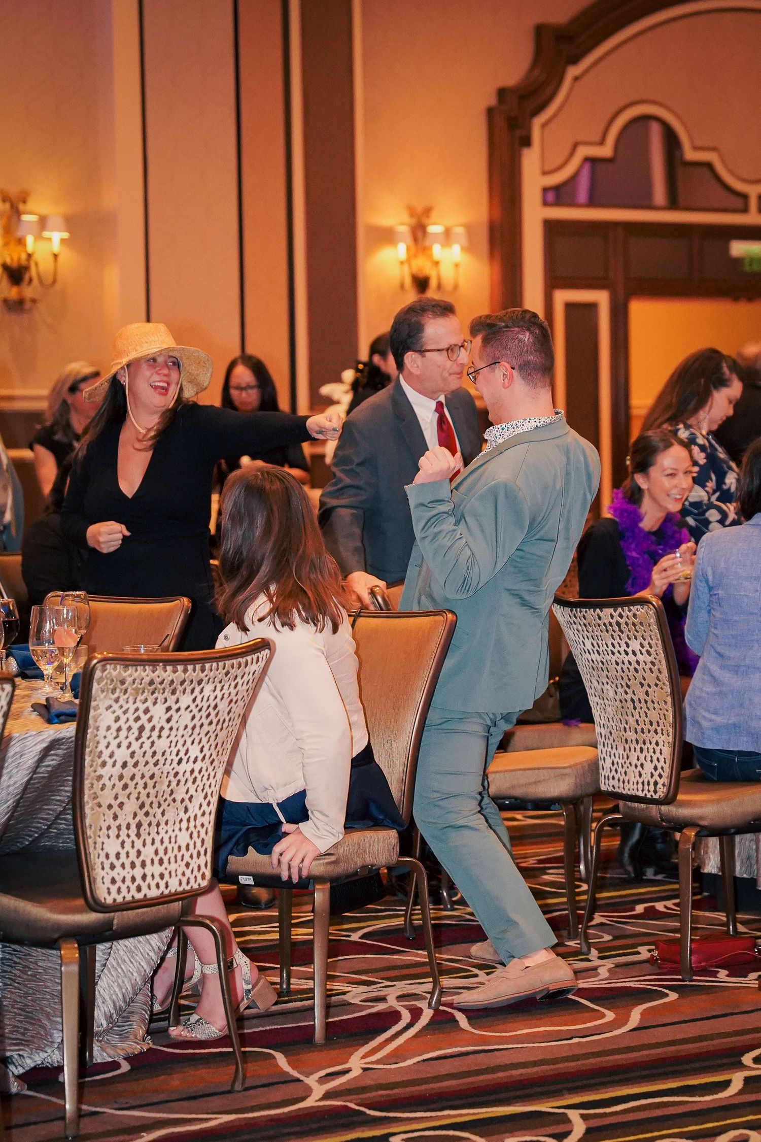 People enjoying a celebratory moment at an elegant indoor banquet or reception.