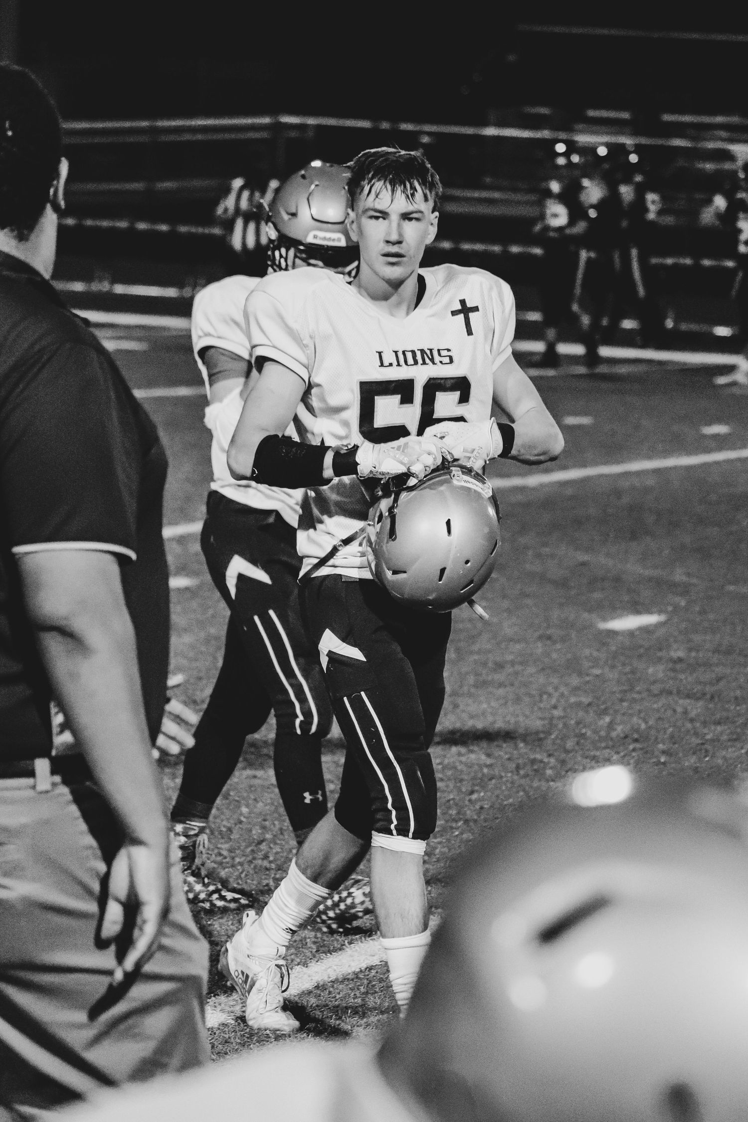 Player in white uniform with number 52 during nighttime football game.
