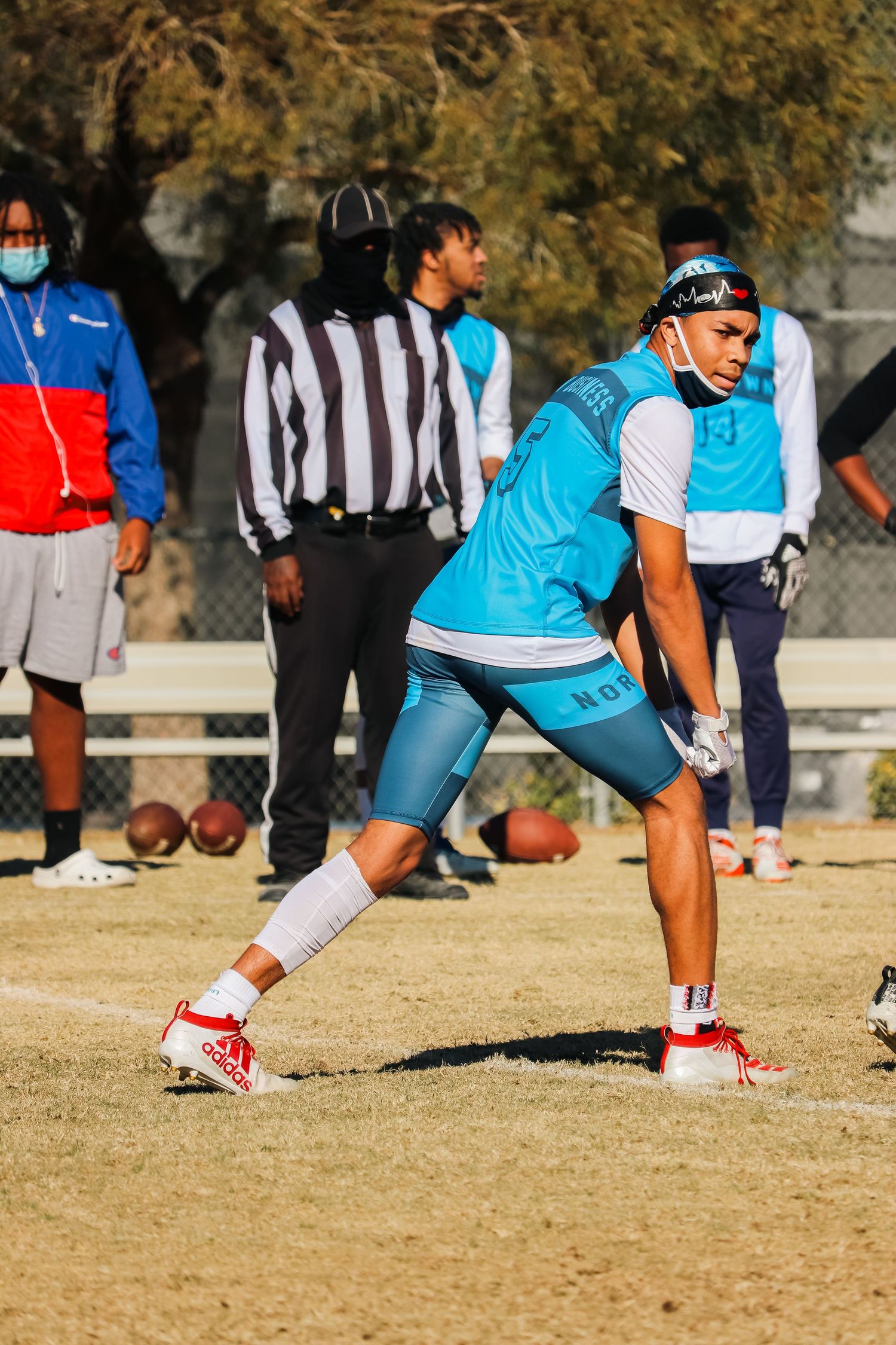 Athletes in bright blue uniforms performing stretching exercises during outdoor practice.