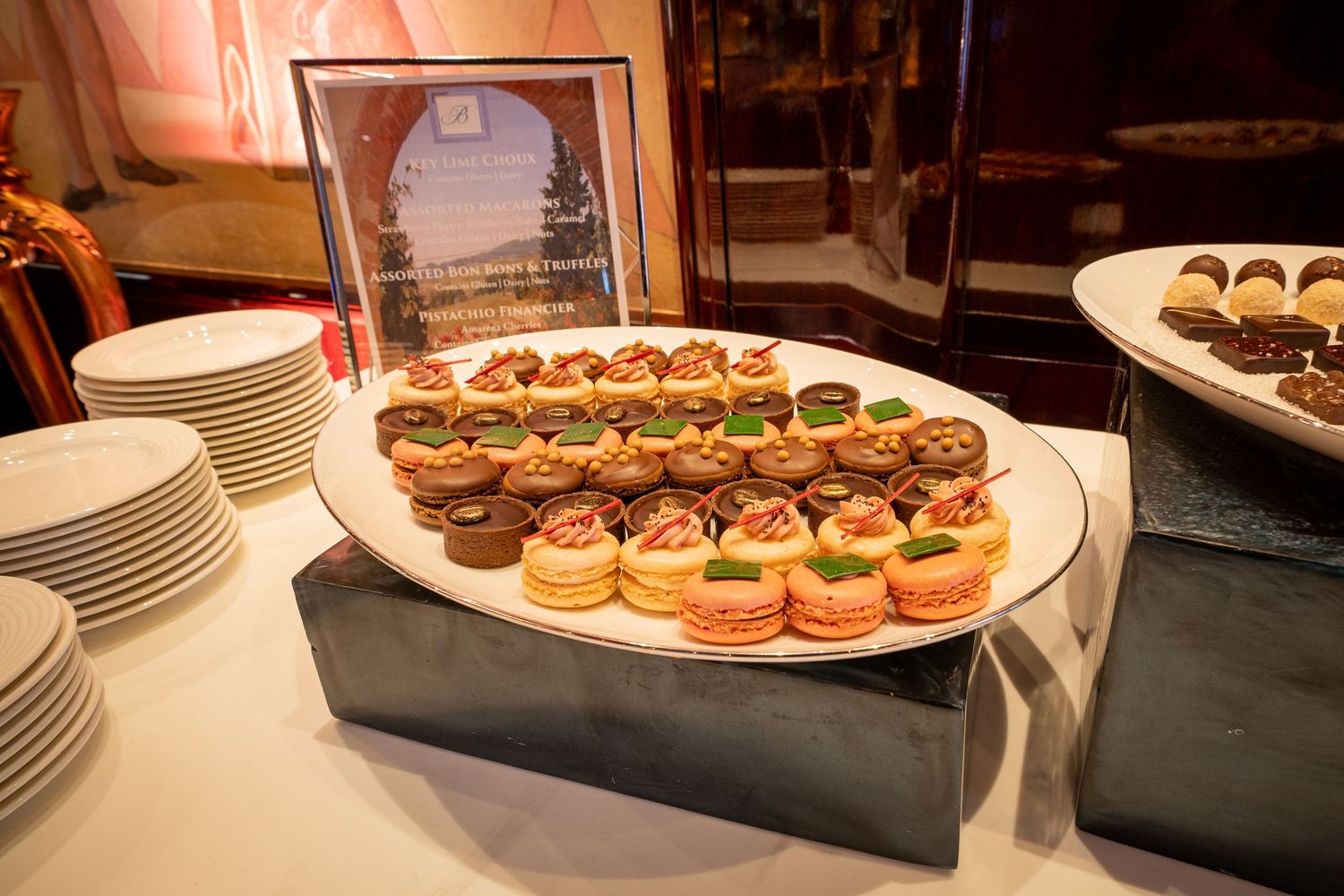 Gourmet mini sandwiches and appetizers arranged on elevated platters for catering service.