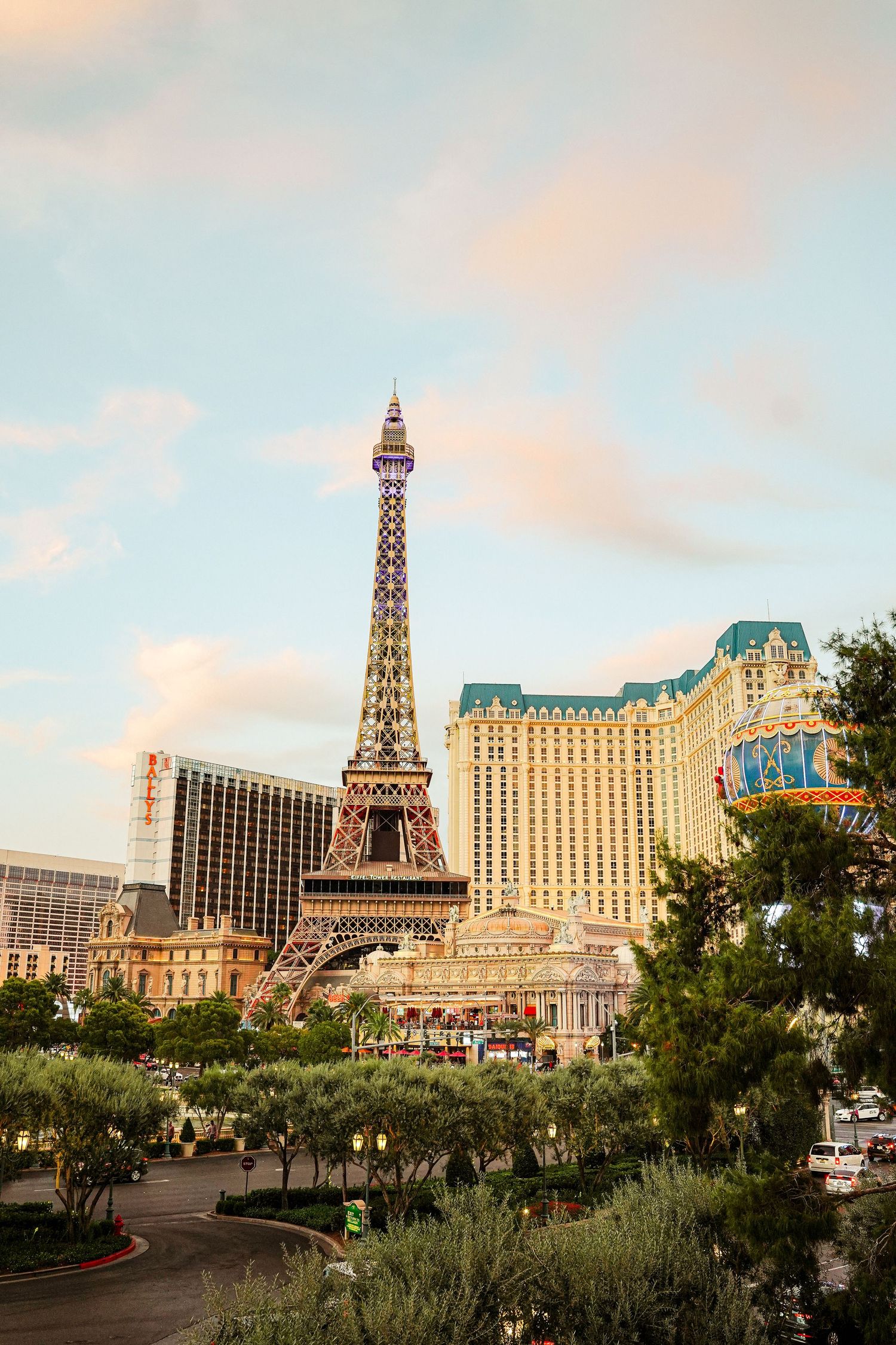 Paris Las Vegas hotel and replica Eiffel Tower against sunset sky on the Vegas Strip.