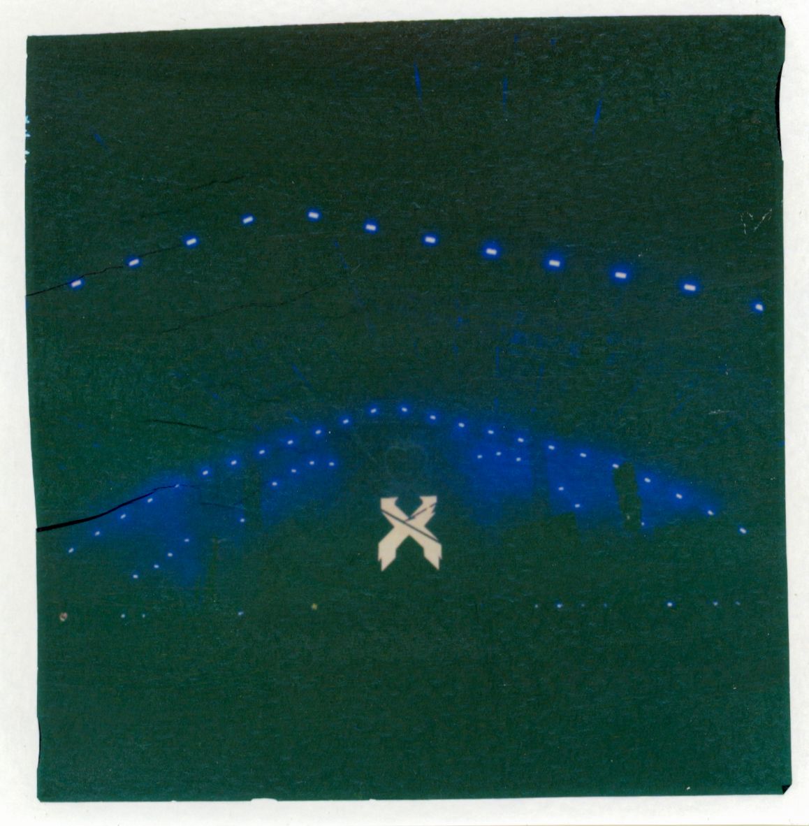 Blue LED lights forming curved lines with glowing X symbol in center against dark sky.