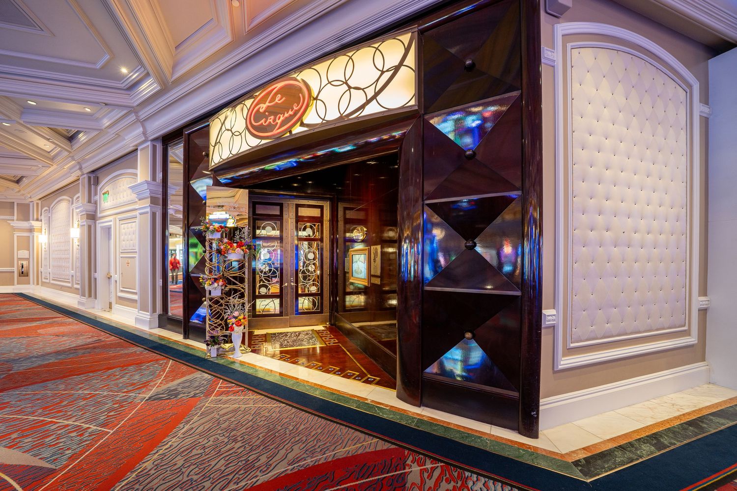 Upscale retail storefront with illuminated display cases and elegant white molding in a cruise ship corridor.
