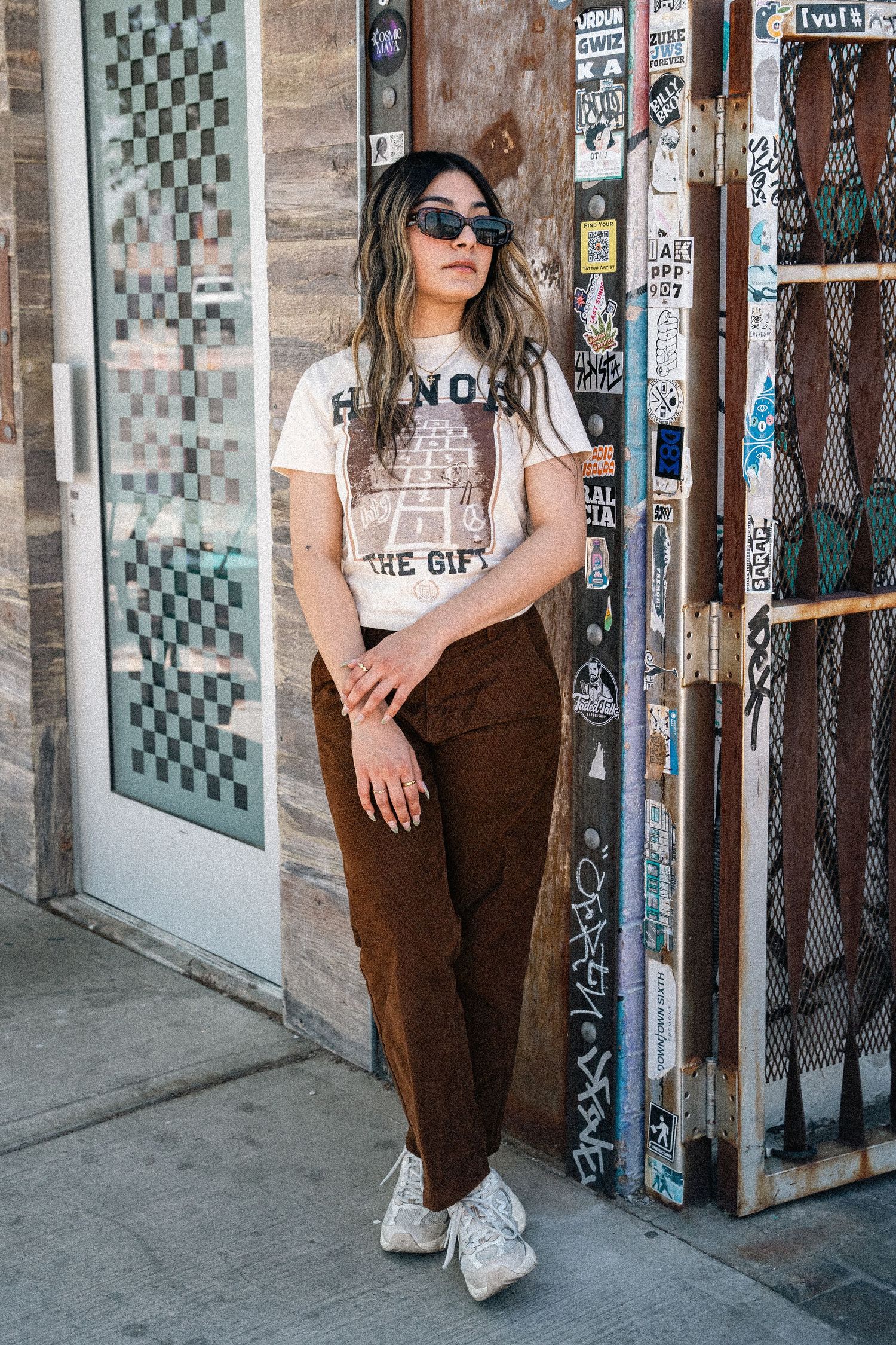 Fashion editorial shots showcasing urban streetwear look against graffiti-covered wall.