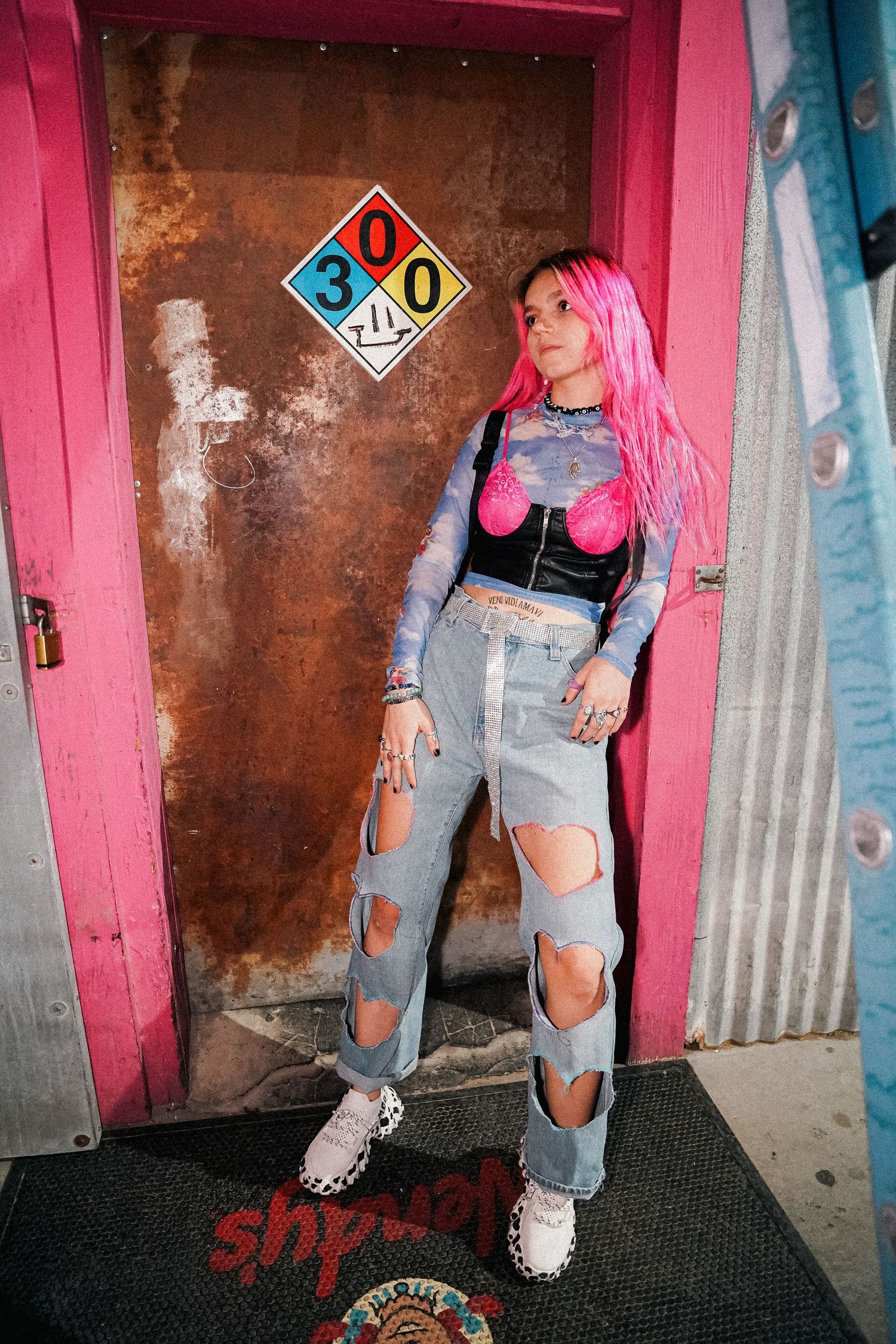 Fashion photo series showing ripped jeans and pink accents against industrial background.