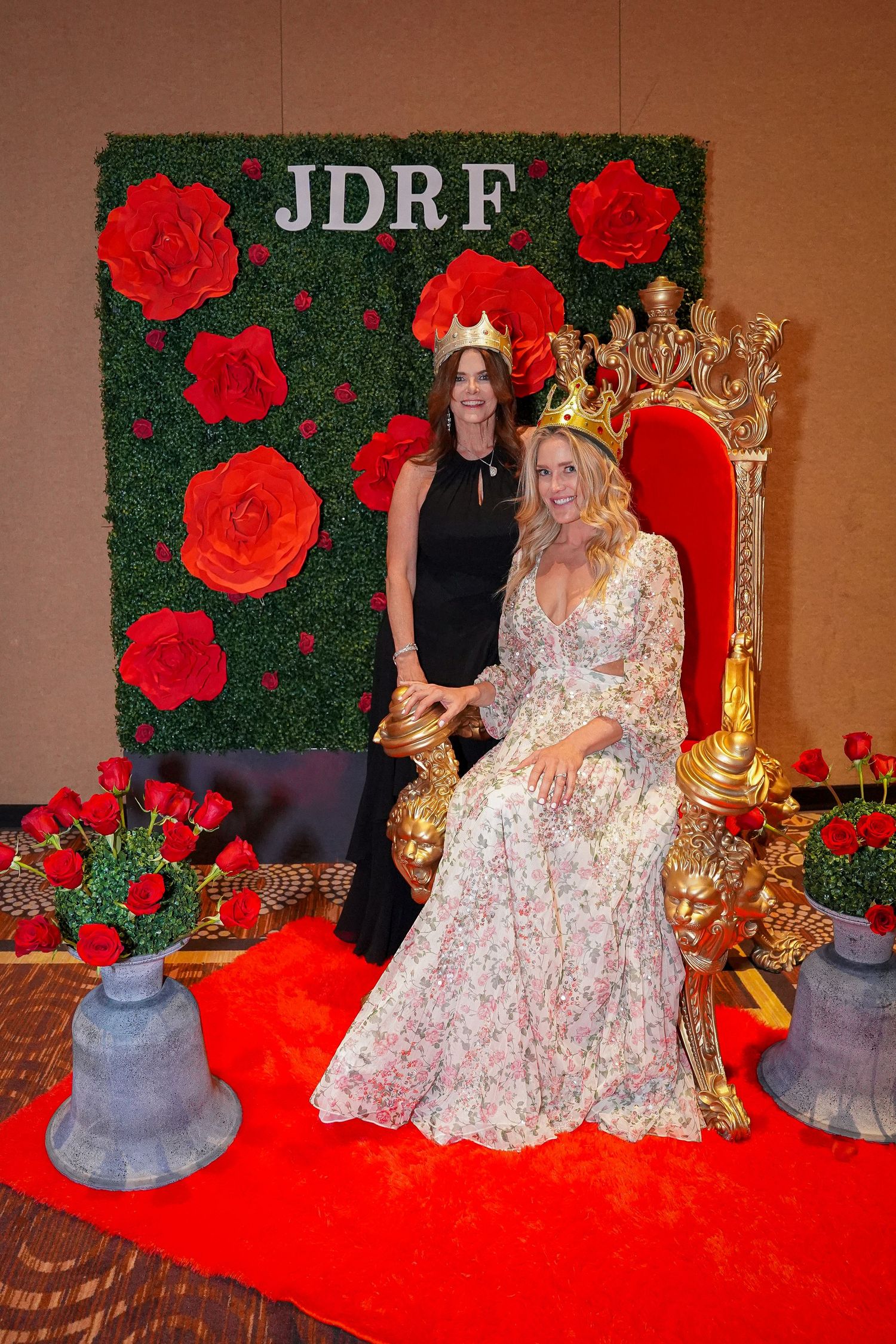 Elegant JDRF event photo area with floral wall, red carpet, and golden throne setup.