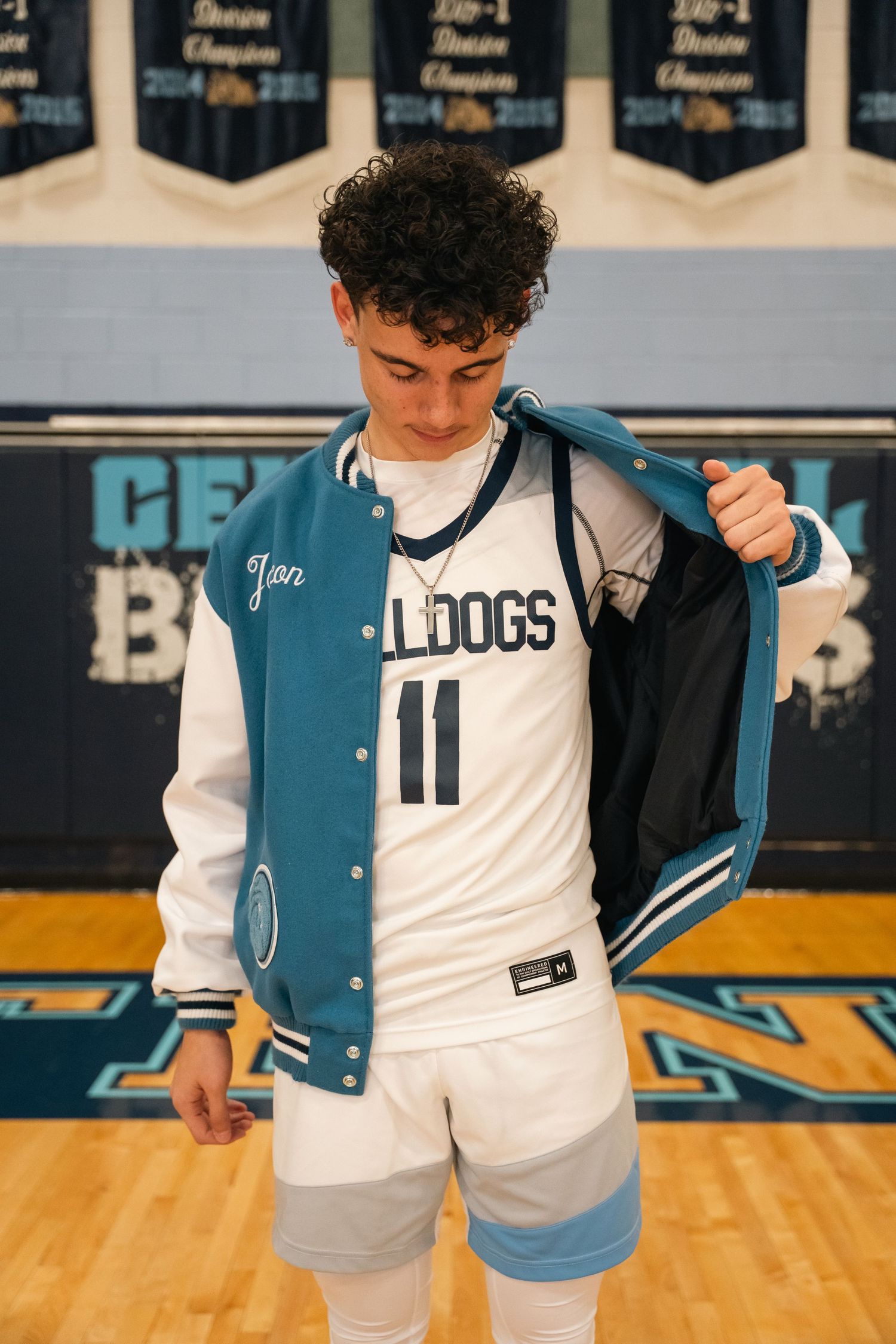 Basketball player puts on letterman jacket over Bulldogs jersey number 11.