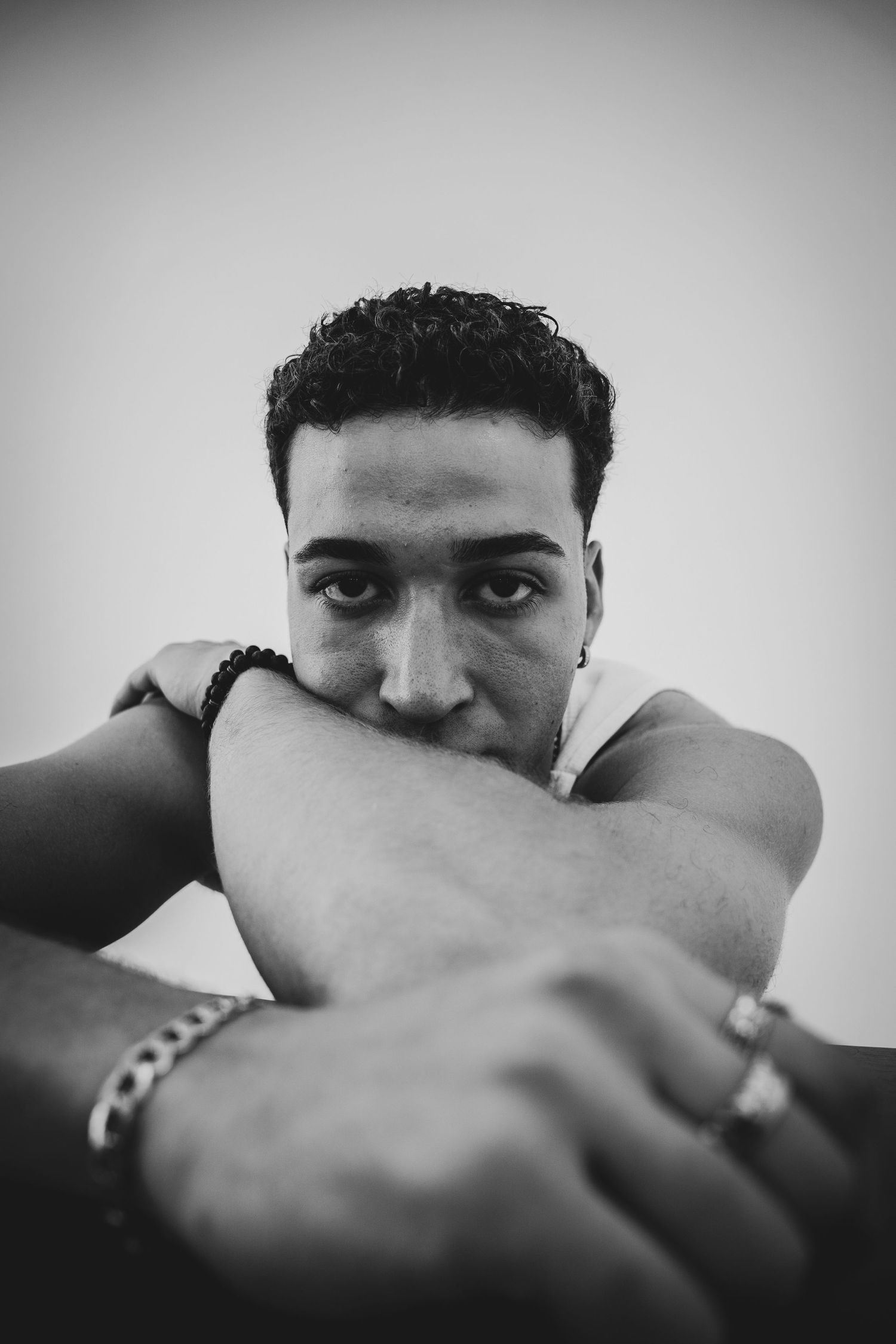 Moody black and white self-portrait with hand partially covering the face creating visual tension.