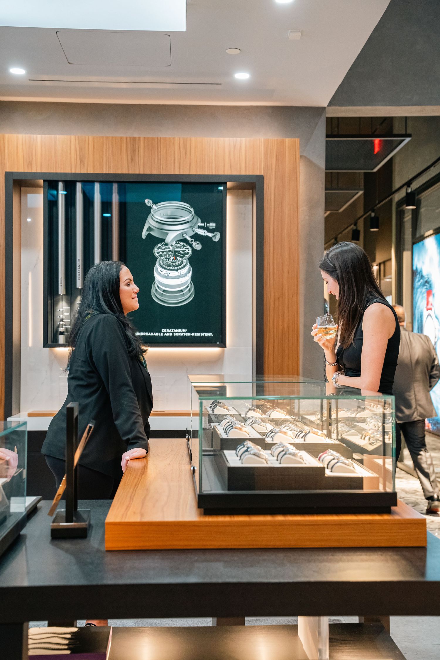 Display cases showcasing luxury watches in a modern retail environment with digital screens.