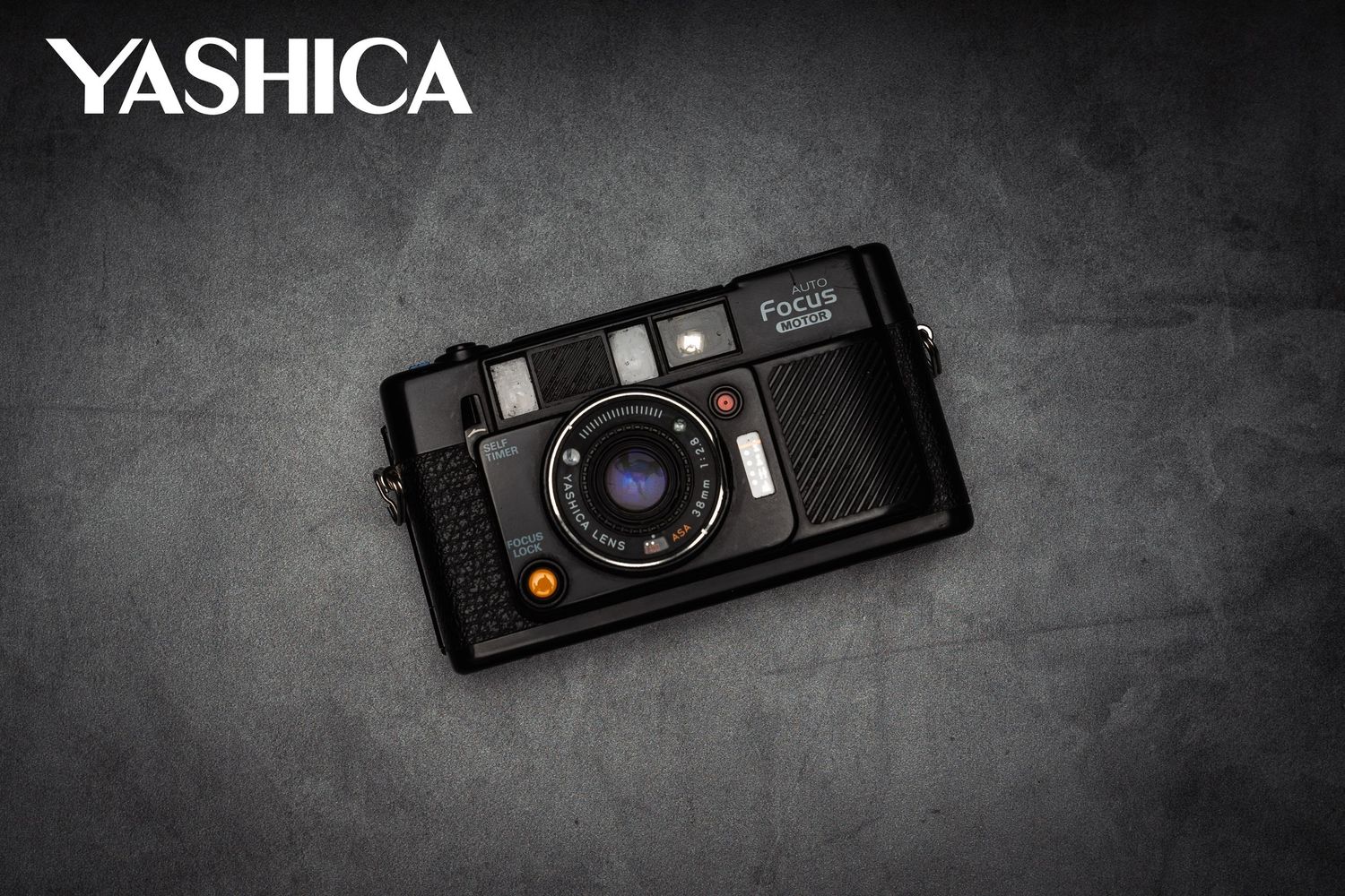 Vintage Yashica film camera displayed on dark textured background.