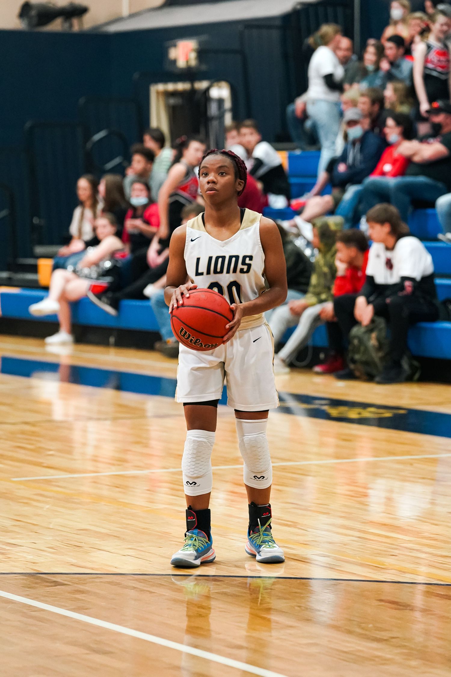 Basketball player in a white Lions jersey prepares to take a free throw shot.